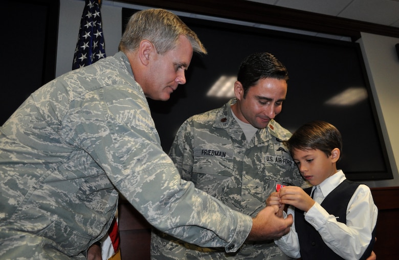 Lt. Gen. Eric E. Fiel, Air Force Special Operations Command commander, hands the Bronze Star medal to Hunter, son of Maj. F. Damon Friedman during a ceremony Nov. 13, 2013, at Hurlburt Field, Fla. Friedman, an AFSOC special tactics officer, was awarded the Bronze Star with Valor for his actions against enemy forces in Afghanistan in April 2010. (U.S. Air Force photo by Master Sgt. Carlotta Holley) 
