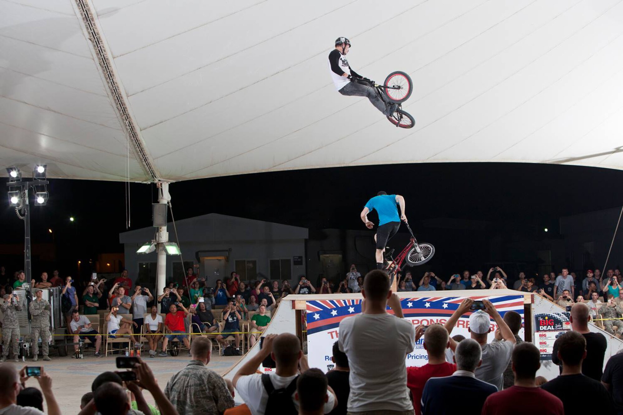 Morgan Wade jumps over Scott Powell during a Bikes Over Baghdad demonstration at the 379th Air Expeditionary Wing in Southwest Asia, Nov. 9, 2013. Wade and Powell are professional BMX riders with the Bikes Over Baghdad group and compete in X-games competitions worldwide. (Courtesy photo by Keith Mulligan)
