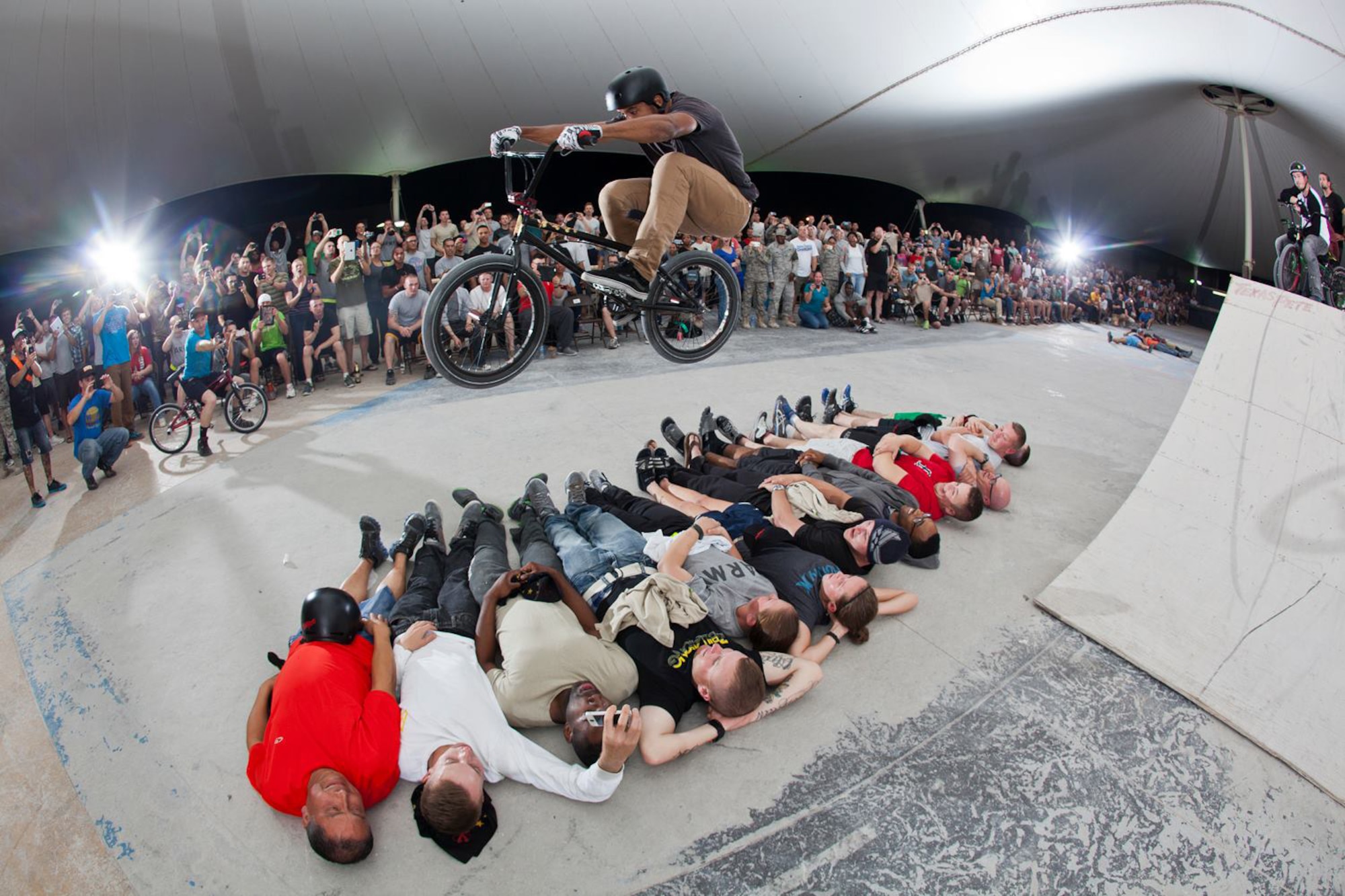 Mykel Larrin jumps over a group of people during a Bikes Over Baghdad demonstration at the 379th Air Expeditionary Wing in Southwest Asia, Nov. 8, 2013. Larrin is a professional BMX rider with the Bikes Over Baghdad group and competes in X-games competitions worldwide. (Courtesy photo by Keith Mulligan)