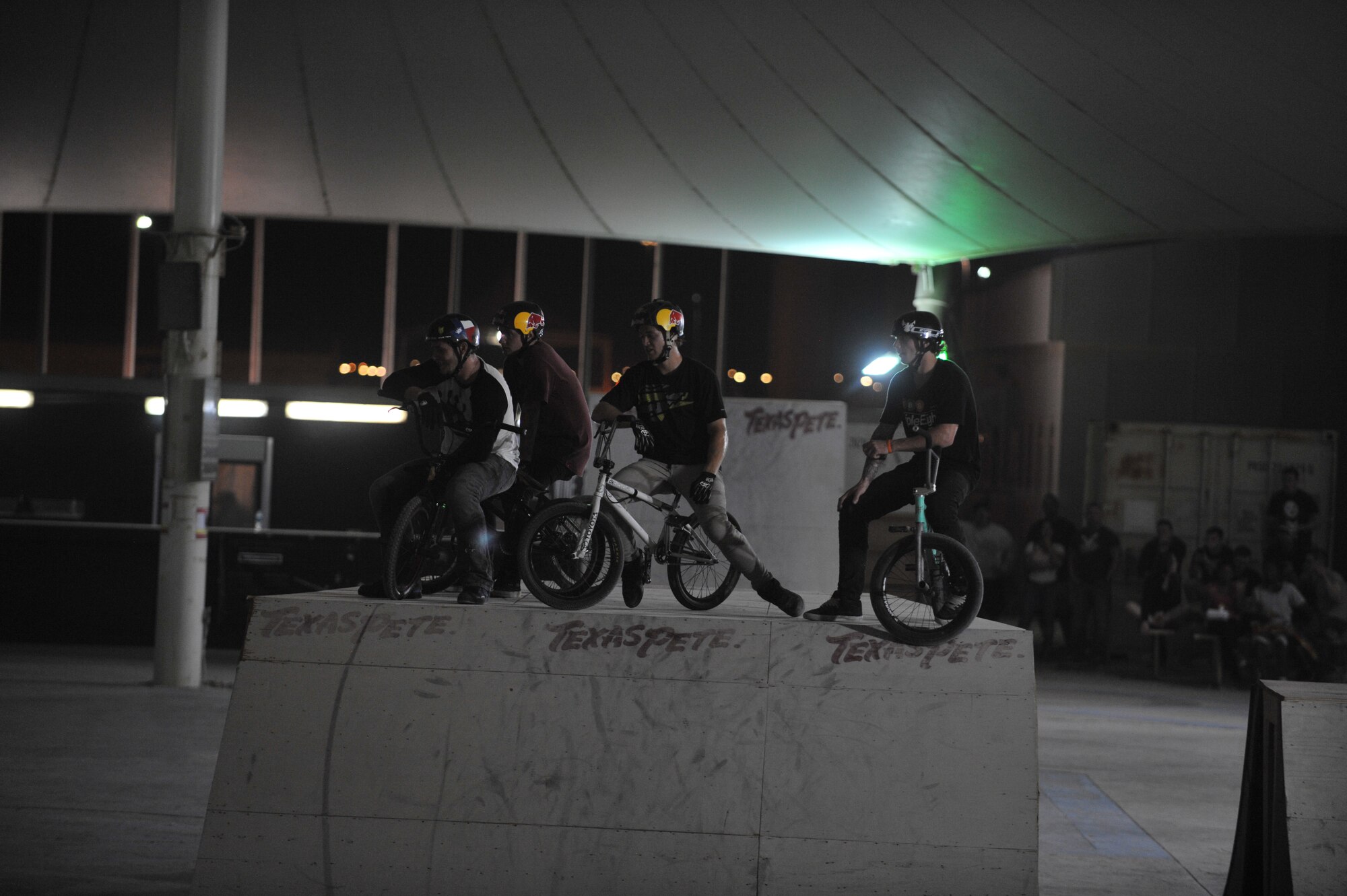 Members of the Bikes Over Baghdad BMX group watch the flatground portion the demonstration at the 379th Air Expeditionary Wing in Southwest Asia, Nov. 9, 2013. The Bikes Over Baghdad team has entertained deployed service members throughout the U.S. Central Command area of responsibility with their BMX stunts for a number of years. (U.S. Air Force photo/Master Sgt. David Miller)