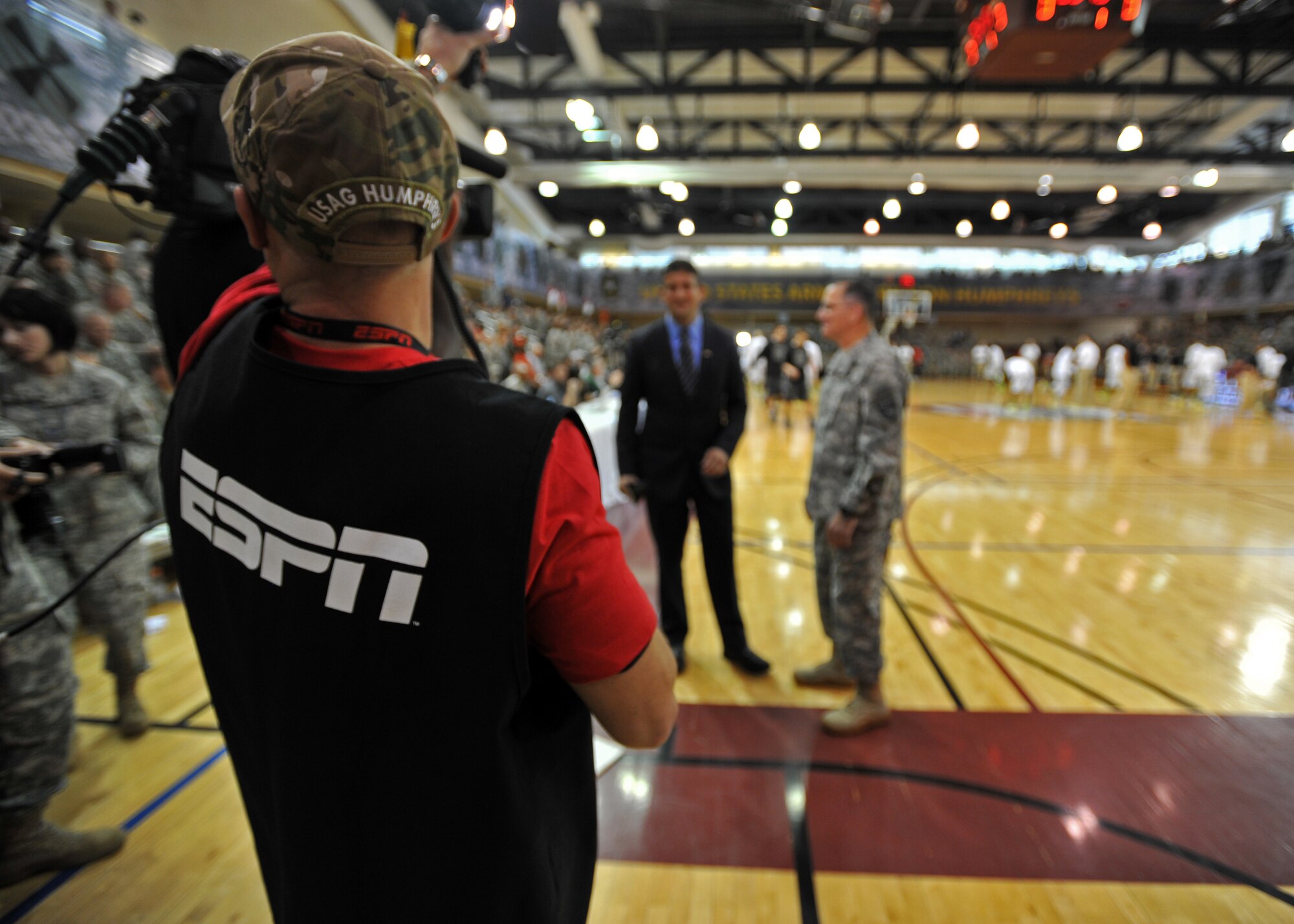 A lighting technician awaits the start of an interview between U.S. Army Gen. Curtis M. Scaparrotti, U.S. Forces Korea commander, and Andy Katz, an ESPN senior college basketball journalist, before the Armed Forces Classic tips off at U.S. Army Garrison Humphreys, Republic of Korea, Nov. 9, 2013. During the days leading up to the game, the teams served soldiers at the dining facility, conducted youth clinics, held open practices and toured Humphreys. (U.S. Air Force photo/Senior Airman Siuta B. Ika)
