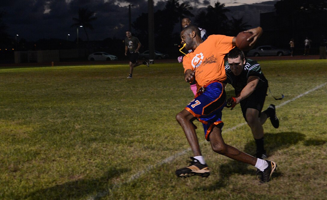 Derek Thorton, Helicopter Sea Combat Squadron 25, runs down the field and avoids having his flag taken Nov. 13, 2013, on Andersen Air Force Base, Guam. The HSC-25 intramural flag football team defeated the 36th Civil Engineer Squadron 40-0. (U.S. Air Force photo by Airman 1st Class Emily A. Bradley/Released)