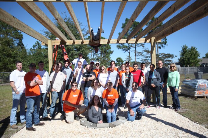 Marines from Marine Corps Air Station New River and Marine Corps Base Camp Lejeune, pose for a photo under the newly-renovated pergola they came together to build as part of Operation Homefront, Oct. 25.