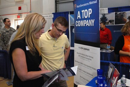 Kristen Cargill, a representative from Northwestern Mutual Financial Network, speaks with New York Army Guard Soldier 1st Lt. John Scott at the U.S. Chamber of Commerce's "Hiring Our Heroes" job fair held at the New York National Guard armory Oct. 16.