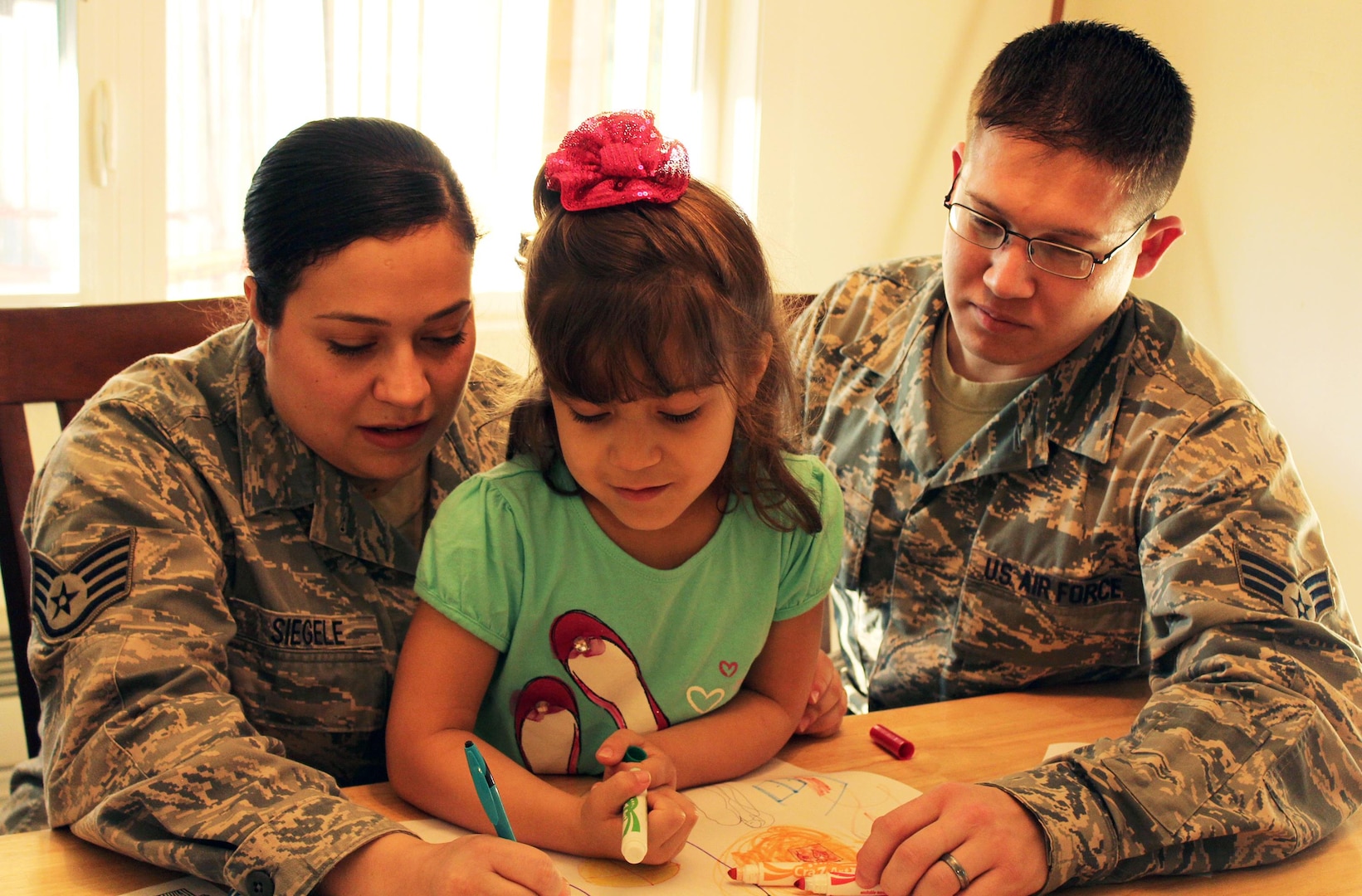 Air Force Staff Sgt. Sabrina Siegele and her husband, Air Force Senior Airman Matt Siegele, enjoy time after work with their daughter, Stephanie, at Joint Base Lewis-McChord, Wash. The Siegeles say they like the age-appropriate scenarios of the new MilitaryParenting.org website.