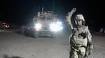 Army 1st Lt. Monicia Porter gives the signal to stop as she guides one of her platoon's vehicles out of their motor pool in preparation to conduct a sustainment and retrograde support mission to a remote location in Northern Afghanistan on Nov 4, 2013. Porter is a platoon leader and convoy commander for the Georgia Army National Guard and is a high school teacher at Central Gwinnett High School in Lawrenceville, Ga.