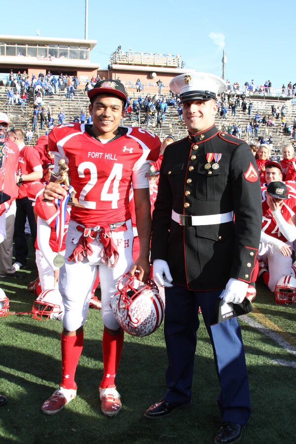 U.S. Marine Lance Cpl. Vincent Monteleone, a Cumberland native, presented the MVP trophy to Ty Johnson at the end of the Great American Rivalry Series game between Fort Hill High School and Allegany High School in Cumberland, Md. Nov. 9, 2013. Monteleone is a reserve Marine with 4th Light Armored Reconnaissance in Frederick, Md., and is assisting Recruiting Sub-station Martinsburg. (U.S. Marine Corps photo by Sgt. Amber Williams/Released)