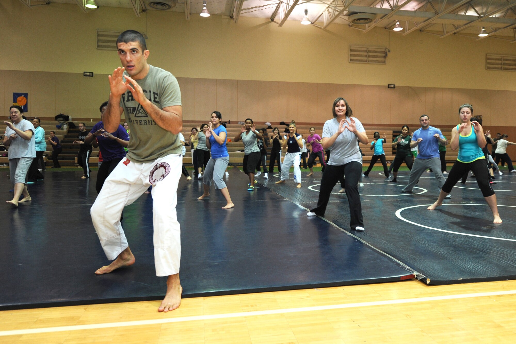 Rener Gracie demonstrates a combat base pose during the Gracie Academy Women Empowered self-defense seminar Nov. 11, 2013, at the fitness center in Malmstrom Air Force Base, Mont. The weeklong self-defense seminar trained nearly 100 participants to become certified instructors. Gracie is a Gracie Academy Women Empowered self-defense seminar instructor.
