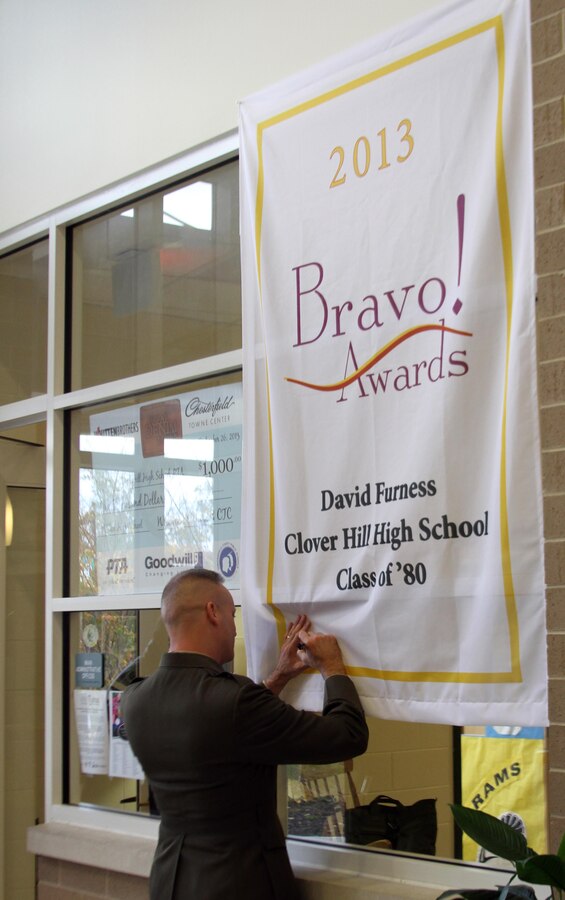 U.S. Marine Corps Brigadier General David Furness, Legislative Assistant to the Commandant of the Marine Corps, signs a banner commemorating his Bravo Award at Clover Hill High School, Nov. 8, 2013. Furness returned to his hometown to accept a Bravo Award from the Chesterfield Public Education Foundation, which recognizes outstanding achievement by graduates from Chesterfield County Public Schools, but also took the opportunity to volunteer to speak at local high schools. (U.S. Marine Corps photo by Cpl. Aaron Diamant/Released)