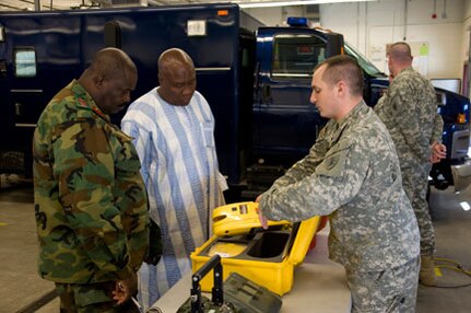 Army Staff Sgt. Jason Horner, of the 81st Civil Support Team, displays some of his unit's equipment for Col. Isaac Mensah Tetteh, director of land operations at the General Headquarters for the Ghana Army, and Kofi Portuphy, national coordinator for the National Disaster Management Agency, at Fraine Barracks, Bismarck, N.D., April 11, 2011.