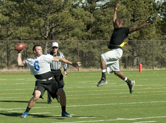 Airman 1st Class Devin Harris jumps to impede the vision of former U.S. Air Force Academy quarterback, 2nd Lt. Brian Lindsay during a game at the Academy Nov. 9, 2013. The game determined which base would have their name etched into the Rocky Mountain Regional Military Championship plaque. Harris is assigned to the 90th Maintenance Operations Squadron. Lindsay is the USAFA Prep School assistant football coach. 
