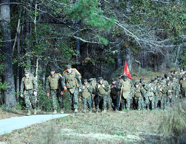 Marines and sailors with 2nd Medical Battalion, Combat Logistics Regiment 25, 2nd Marine Logistics Group crest the last hill before reaching the halfway point during a six-mile hike aboard Camp Lejeune, N.C., Nov. 15, 2013. The hike was used to maintain mission readiness and collect food for families within the battalion who do not have the means to afford a nice Thanksgiving meal.(U.S. Marine Corps photo by Lance Cpl. Shawn Valosin)