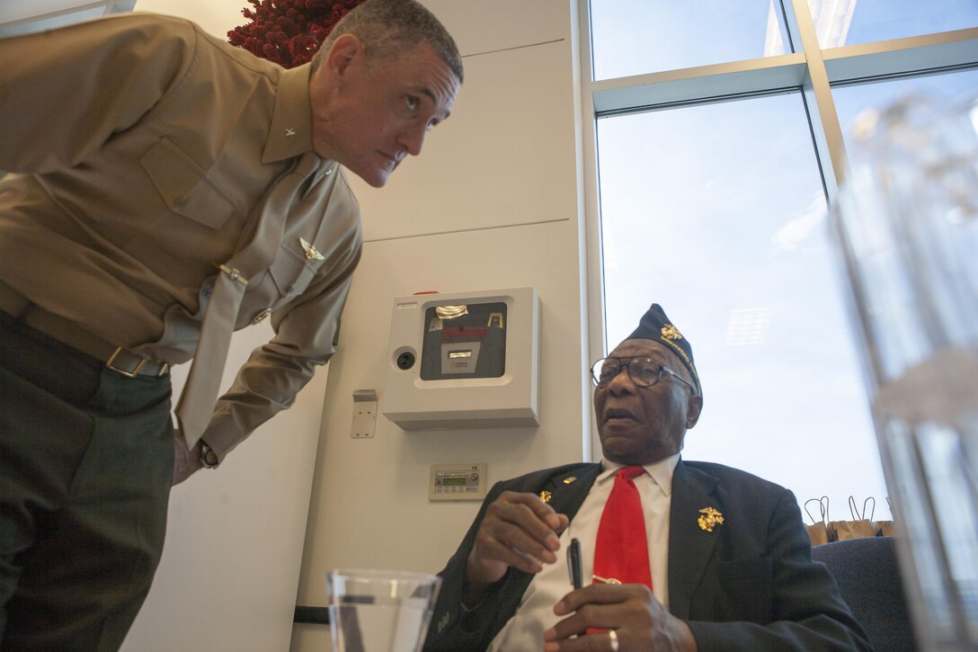 NORFOLK, Va. (Nov. 15, 2013) - William Brown, an original Montford Point Marine from Chesapeake, speaks with Brig. Gen. David W. Coffman, Deputy Commander, U.S. Marine Corps Forces Command, at the Elmore Marine Corps Exchange, Nov. 15. The MCX invited the Montford Point Marines to their grand re-opening to sign autographs and speak with Marines about their experience in the Marine Corps.