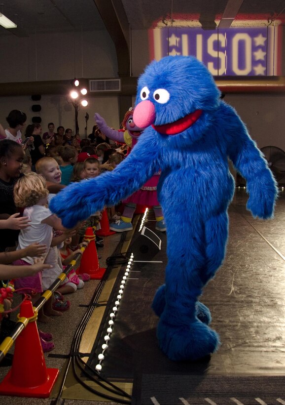 “Sesame Street” character Grover shakes hands and waves to audience members the USO Sesame Street Experience for Military Families event in the training auditorium of building 1090, Nov. 13, 2013. The USO Sesame Street Experience for Military Families featured several familiar characters as well as new character Katie, a military child character. During the show Katie shares her experience of moving to a new duty station. The military child character has been featured in the program since 2011 and appears exclusively during its military performances. (U.S. Marine Corps photo by Kristen Wong)