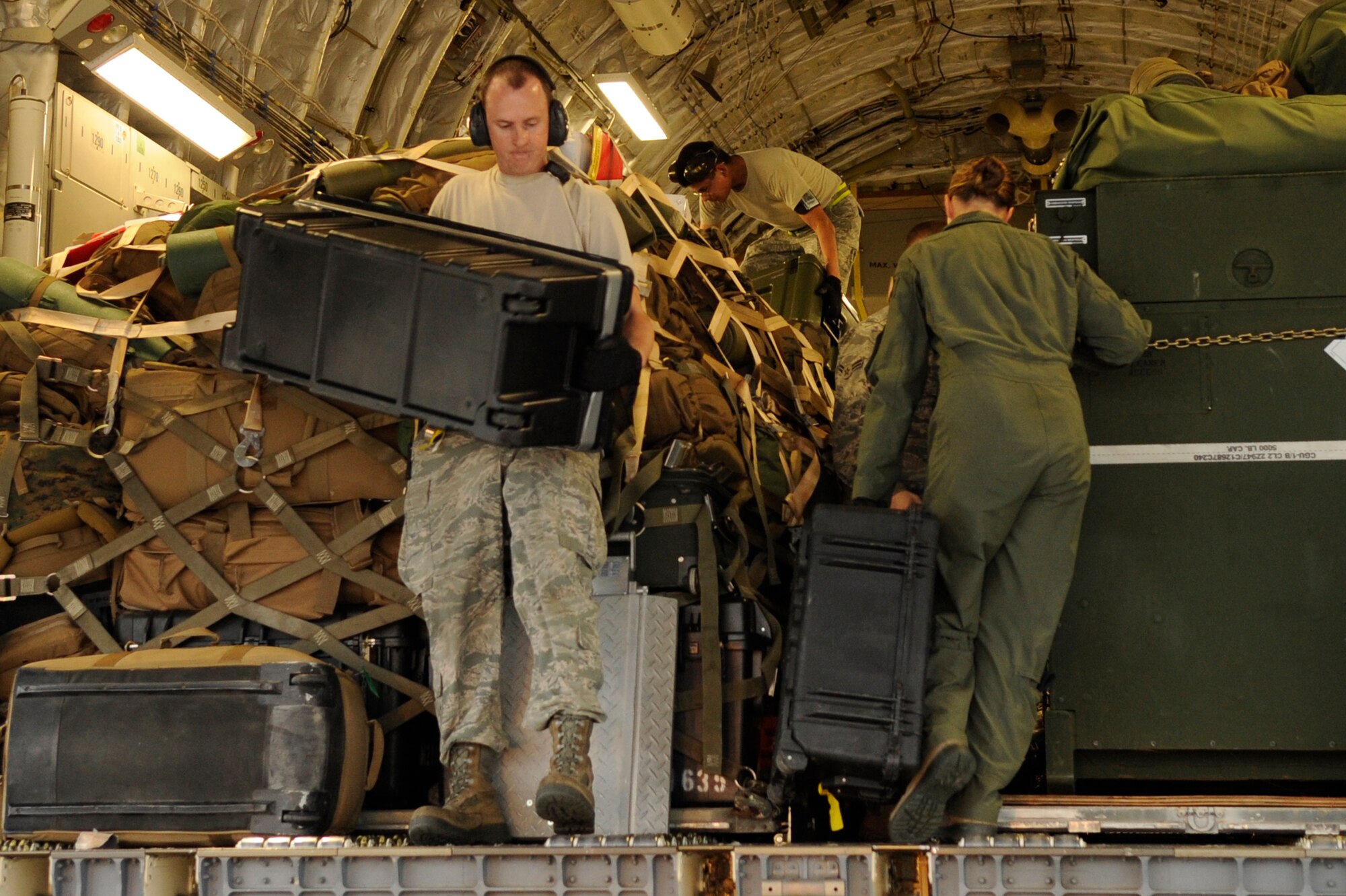 Airmen from the 733rd Air Mobility Squadron load supplies onto a C- 17 Globemaster III from Joint Base Pearl Harbor-Hickam, Hawaii, on Kadena Air Base, Japan, Nov. 15, 2013. Water purifiers and military personnel are being sent to the Philippines to help the locals after the devastation caused by Super Typhoon Haiyan. (U.S. Air Force photo by Senior Airman Marcus Morris) 