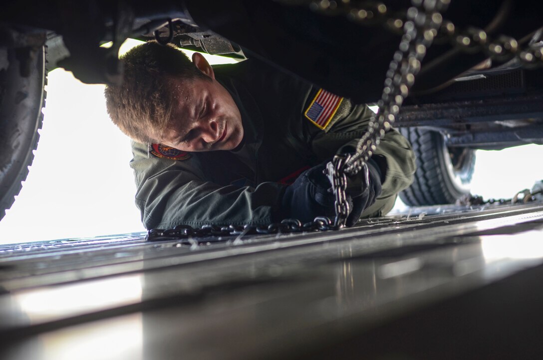 Senior Airman Dylan Porras, 535th Airlift Squadron C-17 Globemaster III loadmaster, secures a Humvee into a C-17 Globemaster III Nov. 15, 2013, on the Andersen Air Force Base, Guam, flightline before departing to support Operation Damayan in Tacloban, Philippines. Operation Damayan is a U.S. humanitarian aid and disaster relief effort to support the Philippines in the wake of the devastating effects of Typhoon Haiyan. (U.S. Air Force photo by Senior Airman Marianique Santos/Released)