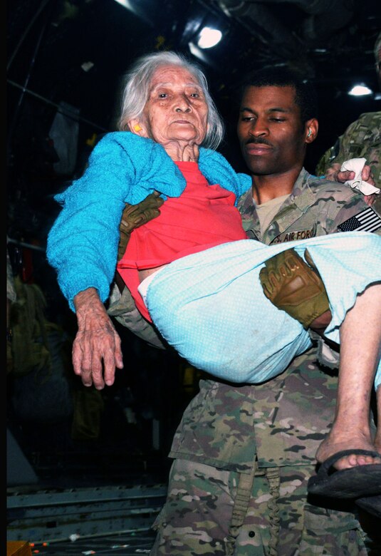 Tech. Sgt. David D. Wheeler, a loadmaster with the 17th Special Operations Squadron, carries a displaced person off an MC-130P Combat Shadow, Nov. 14, 2013 at Tacloban Airport, Philippines.  The displaced people were transported to safety in Manila. Members of Air Force Special Operations Command are deployed alongside U.S. Marine Corps Forces Pacific and the Armed Forces of the Philippines in support of Operation Damayan to provide humanitarian assistance in the aftermath of Typhoon Haiyan. (U.S. Air Force photo by Tech. Sgt. Kristine Dreyer)  