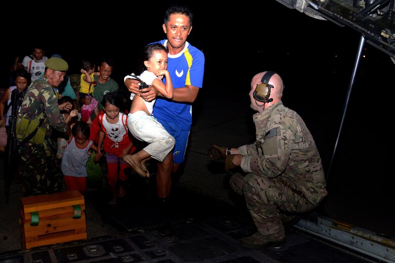 Airman 1st Class Andrew Wiseman, a loadmaster with the 17th Special Operations Squadron, works with members of the Armed Forces of the Philippines to assist displaced people boarding an MC-130P Combat Shadow Nov. 14, 2013 at Tacloban Airport, Philippines. Members of Air Force Special Operations Command are deployed alongside U.S. Marine Corps Forces Pacific and the Armed Forces of the Philippines in support of Operation Damayan to provide humanitarian assistance in the aftermath of Typhoon Haiyan. (U.S. Air Force photo by Tech. Sgt. Kristine Dreyer)  