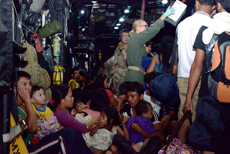 Staff Sgt. Alicia Chavez, 353rd Special Operations Support Squadron independent duty medical technician, passes out ear plugs to displaced people onboard an MC-130P Combat Shadow Nov. 14, 2013, as they are transported from Tacloban Airport to Manila, Philippines. Air Force Special Operations Command Airmen are deployed in support of Operation Damayan, enabling night operations to facilitate the flow of aid. The role of U.S. military forces during any foreign humanitarian assistance event is to rapidly respond to mitigate human suffering and prevent further loss of life. (U.S. Air Force photo by Tech. Sgt. Kristine Dreyer)