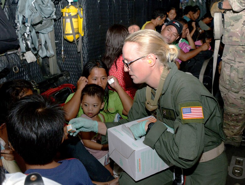Staff Sgt. Alicia Chavez, 353rd Special Operations Support Squadron independent duty medical technician, passes out ear plugs to displaced people onboard an MC-130P Combat Shadow Nov. 14, 2013, as they are transported from Tacloban Airport to Manila, Philippines. Air Force Special Operations Command Airmen are deployed in support of Operation Damayan, enabling night operations to facilitate the flow of aid. The role of U.S. military forces during any foreign humanitarian assistance event is to rapidly respond to mitigate human suffering and prevent further loss of life. (U.S. Air Force photo by Tech. Sgt. Kristine Dreyer)