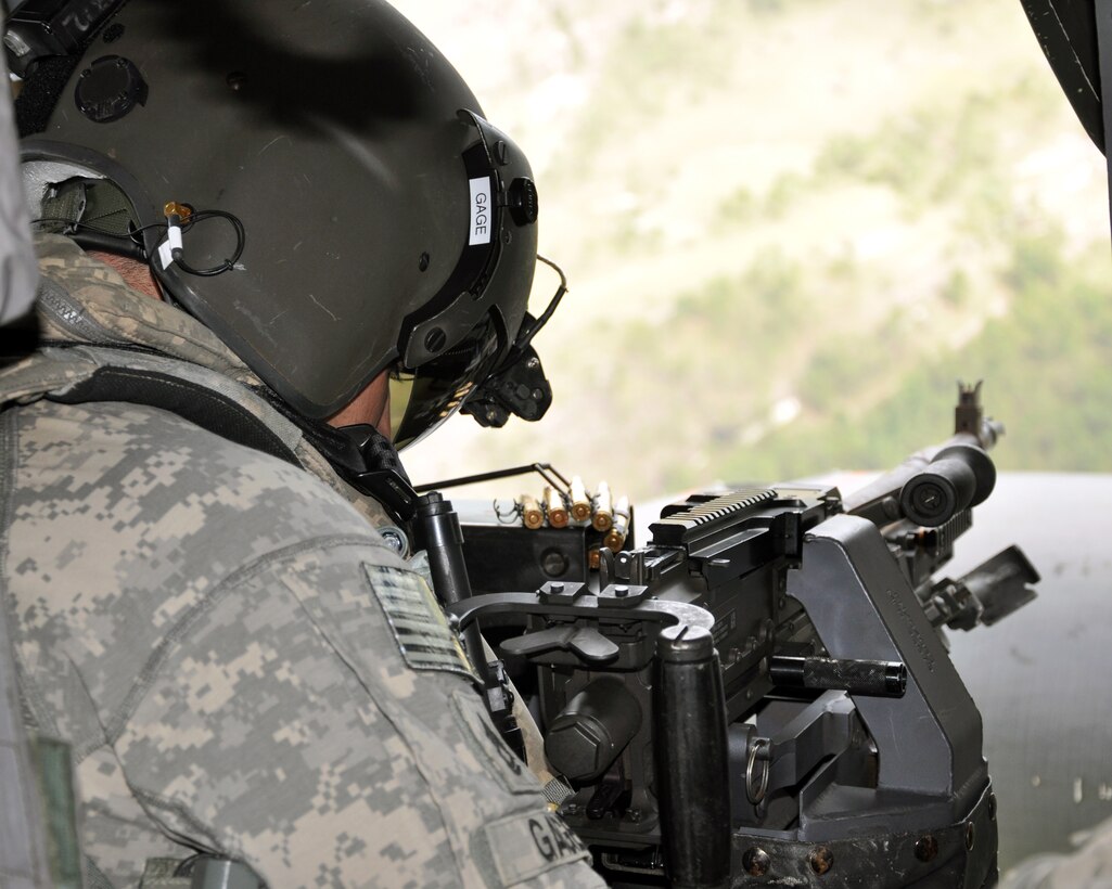 U.S. Army Sgt. 1st Class Steven Gage, 1-228th Aviation Regiment, prepares to fire a M240 machine gun from a UH-60 Blackhawk helicopter during aerial gunnery training, Nov. 15, 2013.  Members of the 1-228th conduct aerial gunnery training regularly in order to maintain currency and proficiency on the weapon system.  (U.S. Air Force photo by Capt. Zach Anderson)  