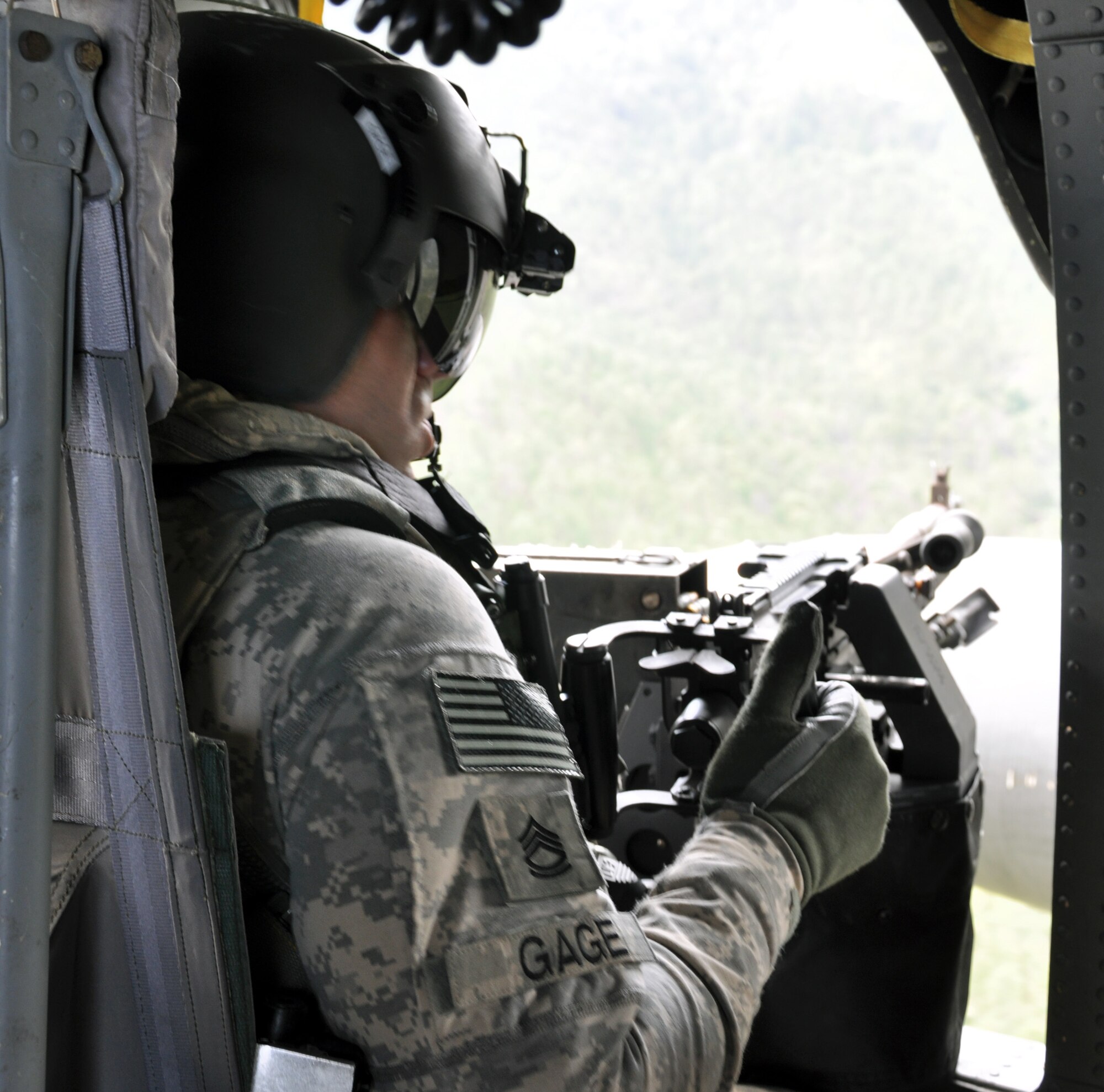 U.S. Army Sgt. 1st Class Steven Gage, 1-228th Aviation Regiment, prepares to fire a M240 machine gun from a UH-60 Blackhawk helicopter during aerial gunnery training, Nov. 15, 2013.  Members of the 1-228th conduct aerial gunnery training regularly in order to maintain currency and proficiency on the weapon system.  (U.S. Air Force photo by Capt. Zach Anderson)  