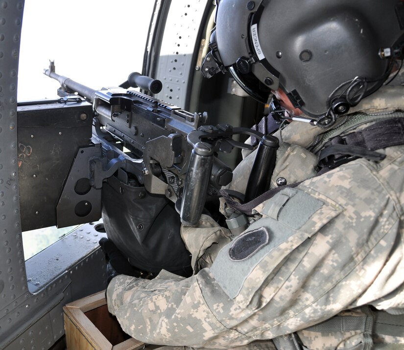 U.S. Army Spc. Brad Spencer, 1-228th Aviation Regiment, prepares to fire a M240 machine gun from a UH-60 Blackhawk helicopter during aerial gunnery training, Nov. 15, 2013.  Members of the 1-228th conduct aerial gunnery training regularly in order to maintain currency and proficiency on the weapon system.  (U.S. Air Force photo by Capt. Zach Anderson)  