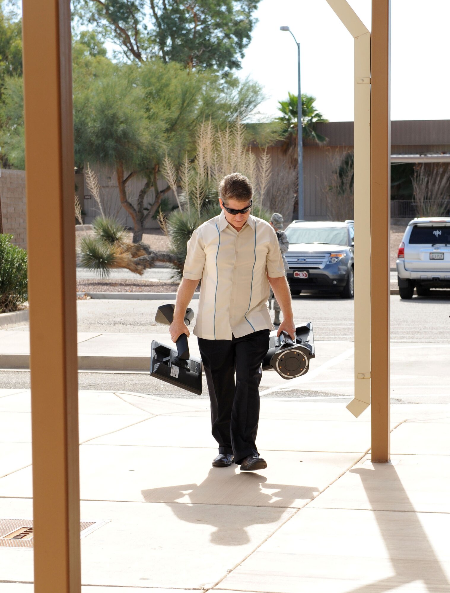 Randal Patterson, General Services Administration area property manager for Arizona, carries two new computer monitors into the Airman and Family Readiness Center where they will be installed as part of a systems upgrade at Davis-Monthan Air Force Base, Ariz., Nov. 11, 2013. More than 20 monitors were transferred to A&FRC accounts through the GSA Federal Acquisition Service which assists government agencies with the procurement of items such as office supplies, computer products, security and furniture. (U.S. Air Force photo by Airman 1st Class Saphfire Cook/Released) (cropped)