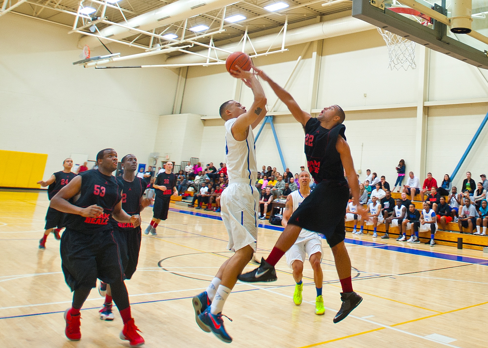 Senior Airman Marcus Devon, a Laboratory Technician at The David Grant USAF Medical Center takes a shot over a Team Beale player in a Tuesday night game at the Travis Fitness Center.  The Travis Hawks won the contest 46 to 43.  (RELEASED; USAF Photo by T.C. Perkins Jr.)
