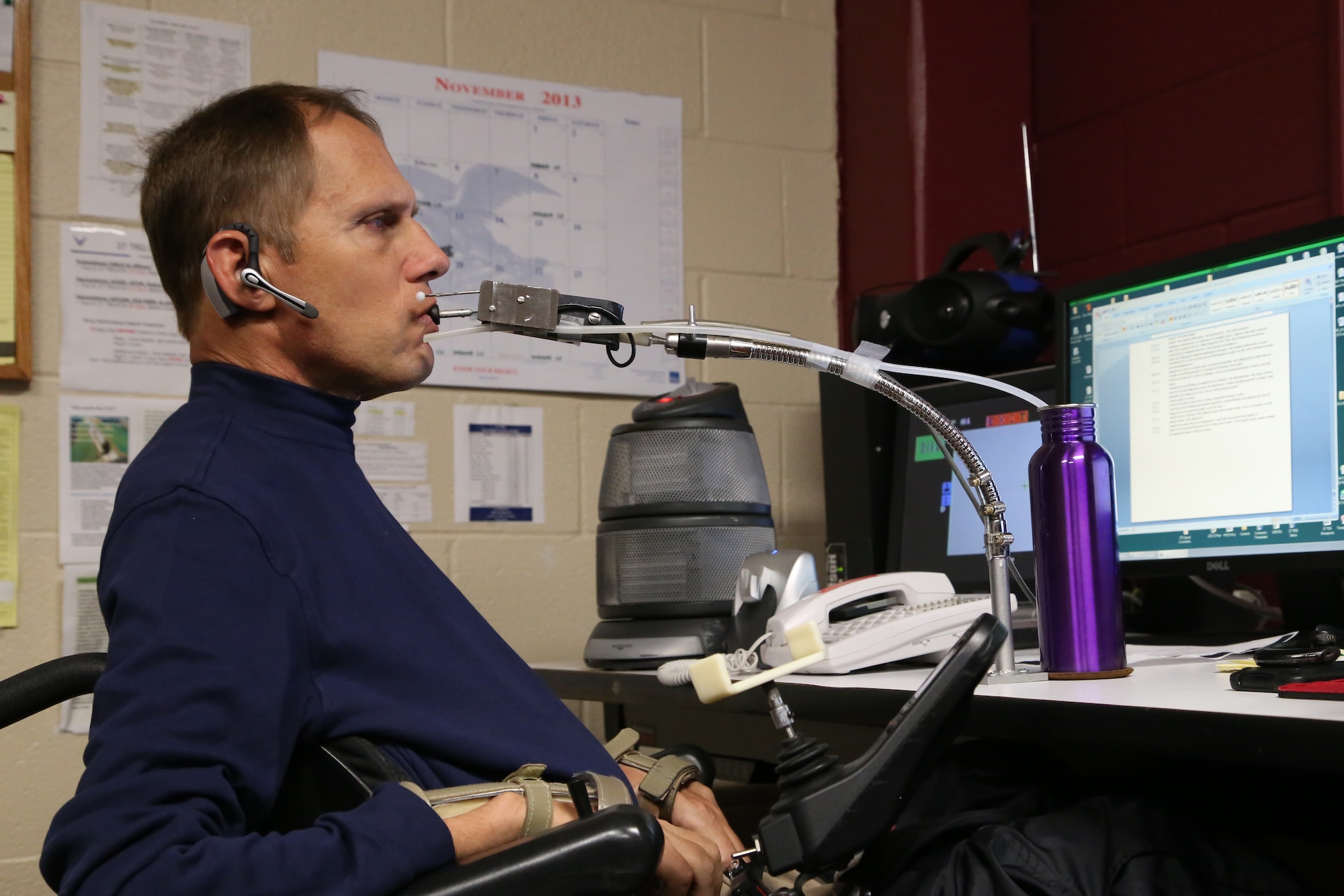 Raymond D. Jenks, 37th Training Support Squadron Instructional Technology Unit Flight Chief, uses an input device (chin controller) to work on his computer.