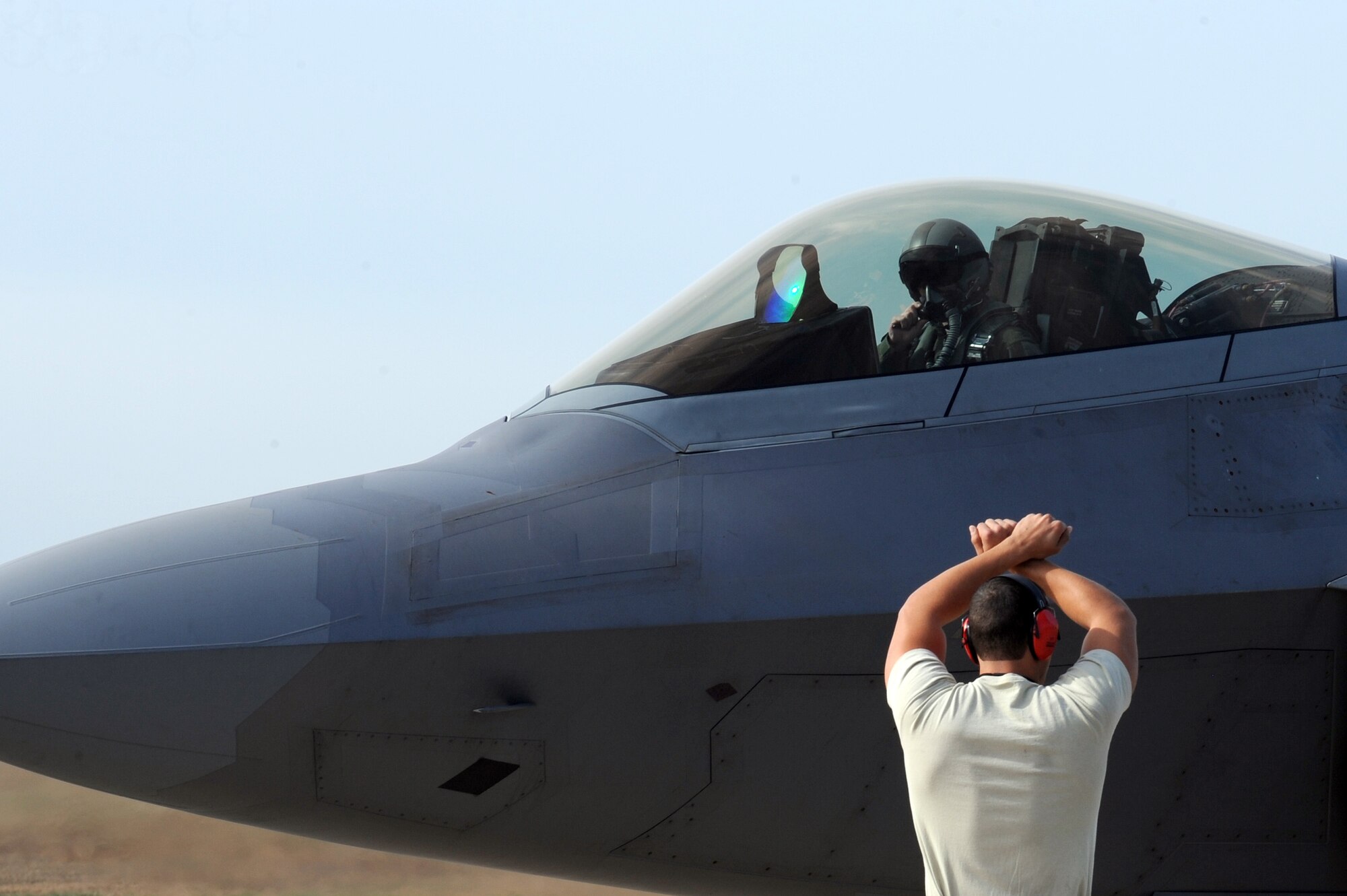 A U.S. Air Force Airman directs an F-22 Raptor pilot to stop at Seymour Johnson Air Force Base, N.C., Nov. 15, 2013. Several F-22s came from Langley Air Force Base, Va., to participate in Exercise RAZOR TALON hosted by the 4th Fighter Wing, a joint service exercise incorporating resources from multiple units along the East Coast. (U.S. Air Force photo by Airman 1st Class Aaron J. Jenne)