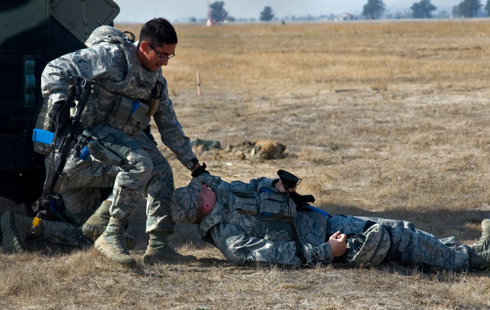 U.S. Air Force Airman 1st Class David Ramos, 570th Global Mobility Readiness Squadron, drags Staff Sgt. Timothy Hooper, 570th GMRS, to safety following a simulated firefight during a Golden Bear exercise Nov. 6, 2013, at Travis Air Force Base, Calif.  (U.S. Air Force photo/Senior Airman Charles Rivezzo)
