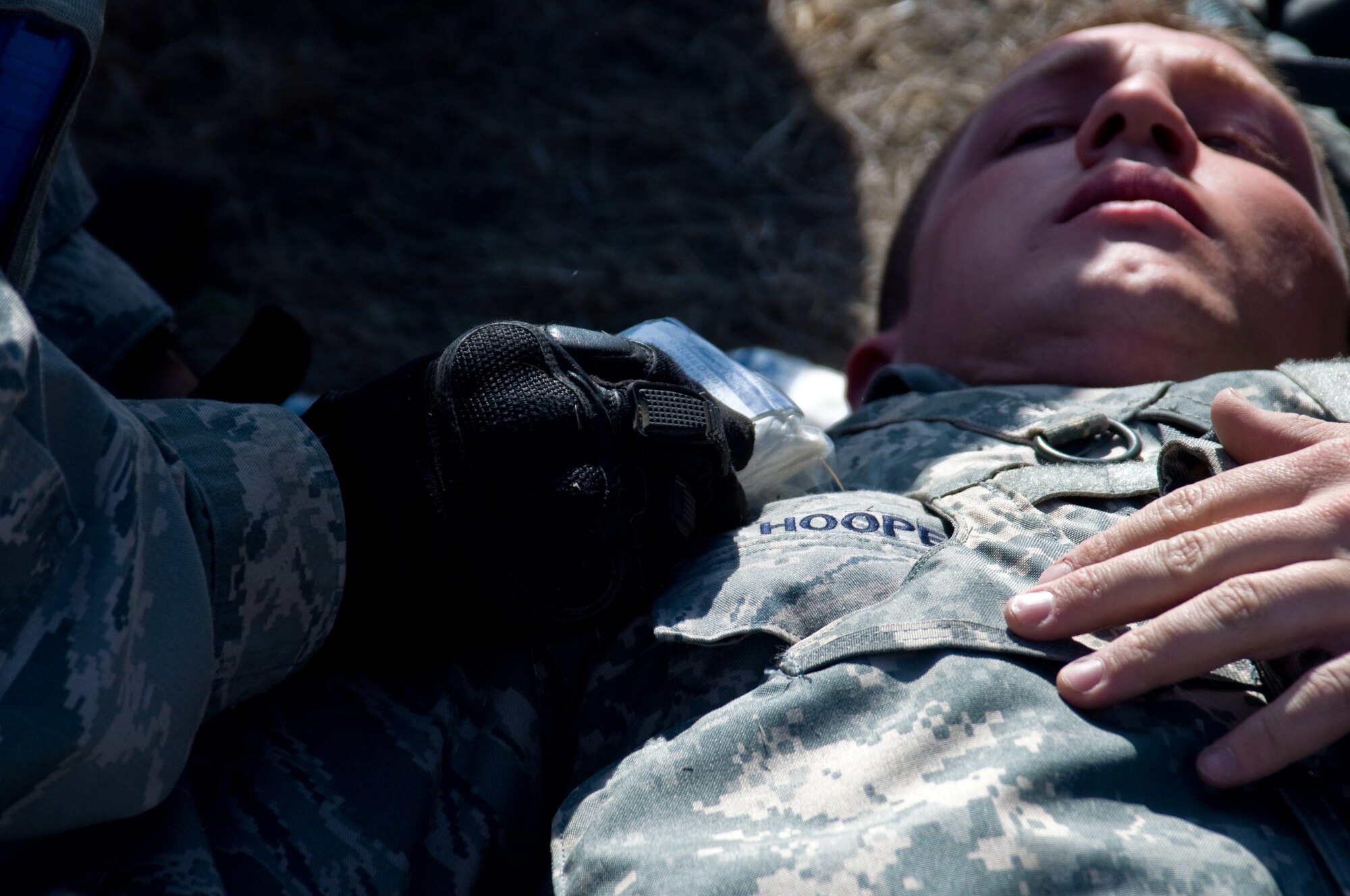 U.S. Air Force Airman 1st Class David Ramos, 570th Global Mobility Readiness Squadron, performs self aid buddy care on Staff Sgt. Timothy Hooper, 570th GMRS, after a simulated firefight during a Golden Bear exercise Nov. 6, 2013, at Travis Air Force Base, Calif. (U.S. Air Force photo/Senior Airman Charles Rivezzo)