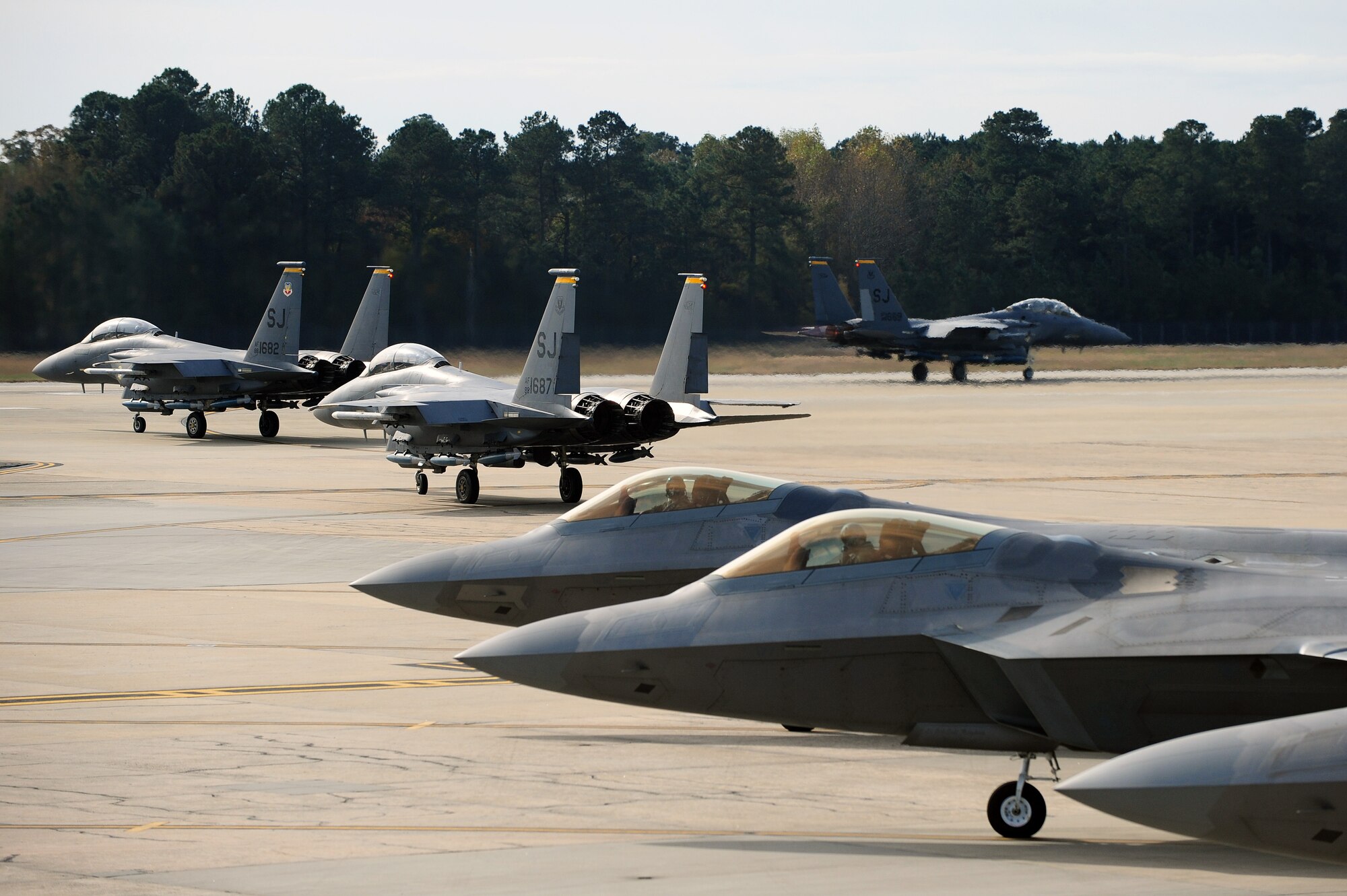 F-22 Raptor and F-15E Strike Eagle aircraft prepare for take-off during Exercise RAZOR TALON at Seymour Johnson Air Force Base, N.C., Nov. 15, 2013. The joint-exercise tested the war fighting capabilities of the different aircraft involved, including F-15s, F-22s, F-16 Fighting Falcons and KC-135R Stratotankers. (U.S. Air Force photo by Airman 1st Class John Nieves Camacho)