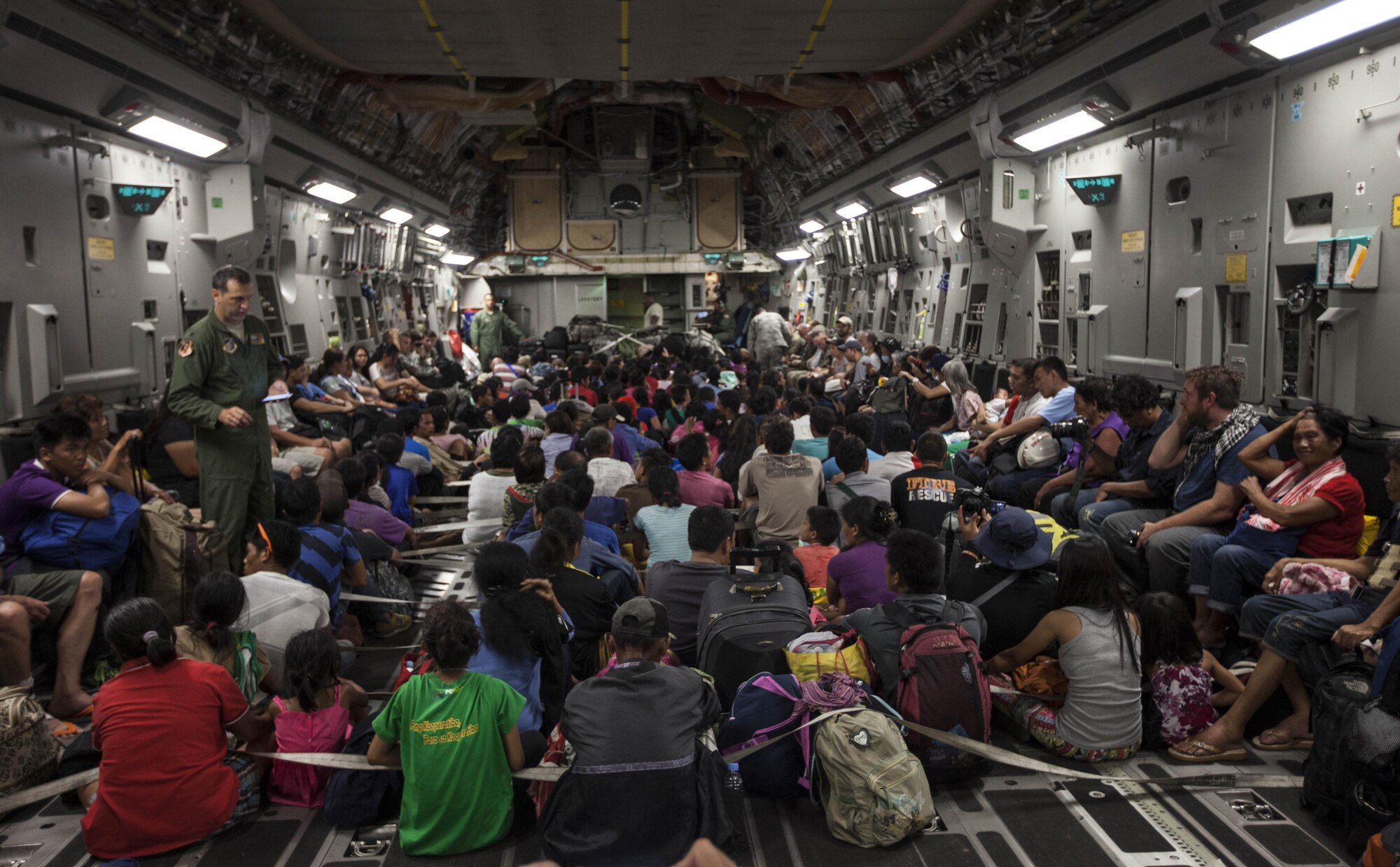Displaced Filipino and other international personnel prepare for takeoff inside a C-17 Globemaster III with the 535th Air Lift Squadron out of Hickam Field, Honolulu, HI, for transport to Manila from Tacloban Air Field, Nov. 15. The supply drop-off and personnel loading was the first use of the C-17 during Operation Damayan, able to carry significantly more supplies and displaced persons than the C-130 Hercules aircraft currently being utilized. To date, the multi-national force has delivered more than 623,000 pounds of relief aid. The 3rd MEB is currently supporting the Armed Forces of the Philippines in providing humanitarian aid and disaster relief to areas affected by Super Typhoon Haiyan/Yolanda.