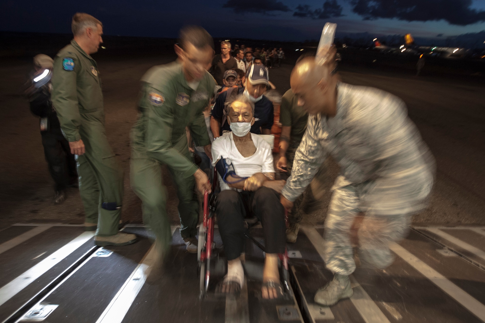 United States airmen assist an elderly Filipino in a wheelchair and other displaced persons aboard a C-17 Globemaster III with the 535th Air Lift Squadron out of Hickam Field, Honolulu, HI, for transport to Manila from Tacloban Air Field, Nov. 15. The supply drop-off and personnel loading was the first use of the C-17 during Operation Damayan, able to carry significantly more supplies and displaced persons than the C-130 Hercules aircraft currently being utilized. To date, the multi-national force has delivered more than 623,000 pounds of relief aid. The 3rd MEB is currently supporting the Armed Forces of the Philippines in providing humanitarian aid and disaster relief to areas affected by Super Typhoon Haiyan/Yolanda.