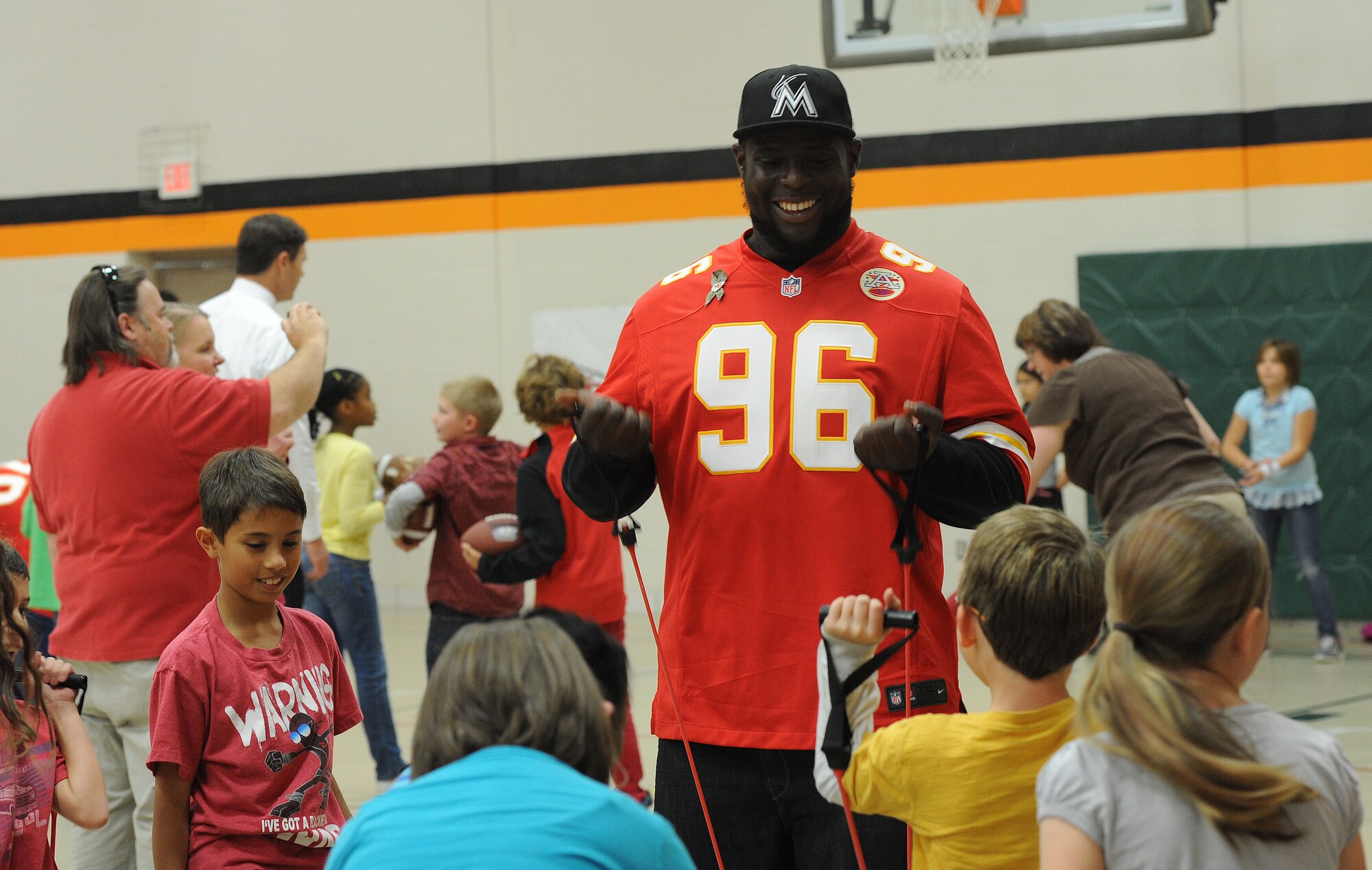 Howard Jaye, a defensive tackle for the Kansas City Chiefs, demonstrates elastic band workouts to elementary school children at Whiteman Air Force Base, Mo., Nov. 12, 2013.  Jaye and four other members of the Chiefs defensive line visited Whiteman Elementary School to exhibit different workouts and drills the team has and to show the children the importance of fitness. (U.S. Air Force photo by Staff Sgt. Nick Wilson/Released)