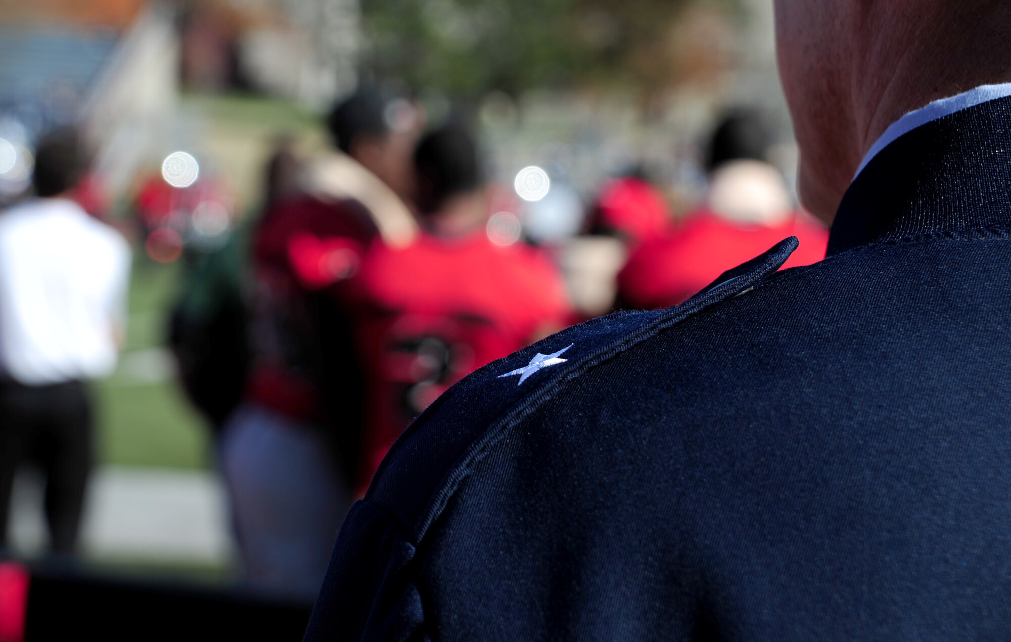 U.S. Air Force Brig. Gen. Thomas Bussiere, 509th Bomb Wing commander, watches as the University of Central Missouri marching band plays a song on the field before a UCM Mule military appreciation football game, in Warrensburg, Mo., Nov. 9, 2013. Each year UCM hosts a military appreciation game to show gratitude to members of the armed forces past and present for serving their country. (U.S. Air Force photo by Staff Sgt. Nick Wilson/Released)