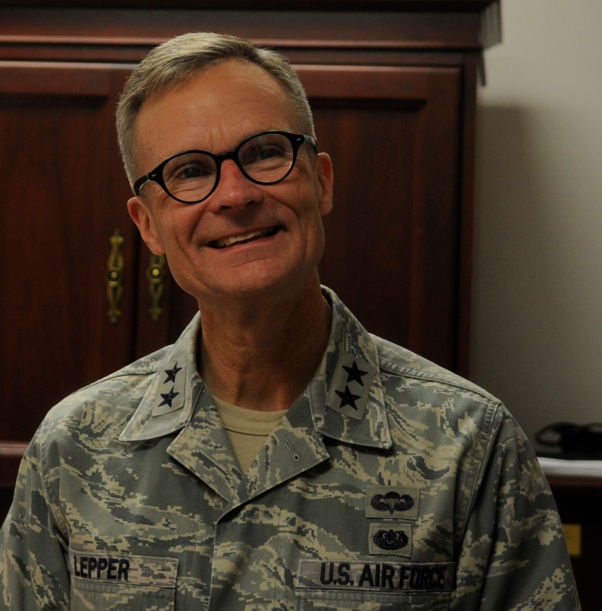 U.S. Air Force Maj. Gen Steven Lepper, Air Force deputy judge advocate general, laughs with a paralegal technician in the legal office at Whiteman Air Force Base, Mo., Nov. 7, 2013. Lepper visited the base to tour both the legal and Area Defense Counsel offices. (U.S. Air Force photo by Staff Sgt. Alexandra Boutte/Released)