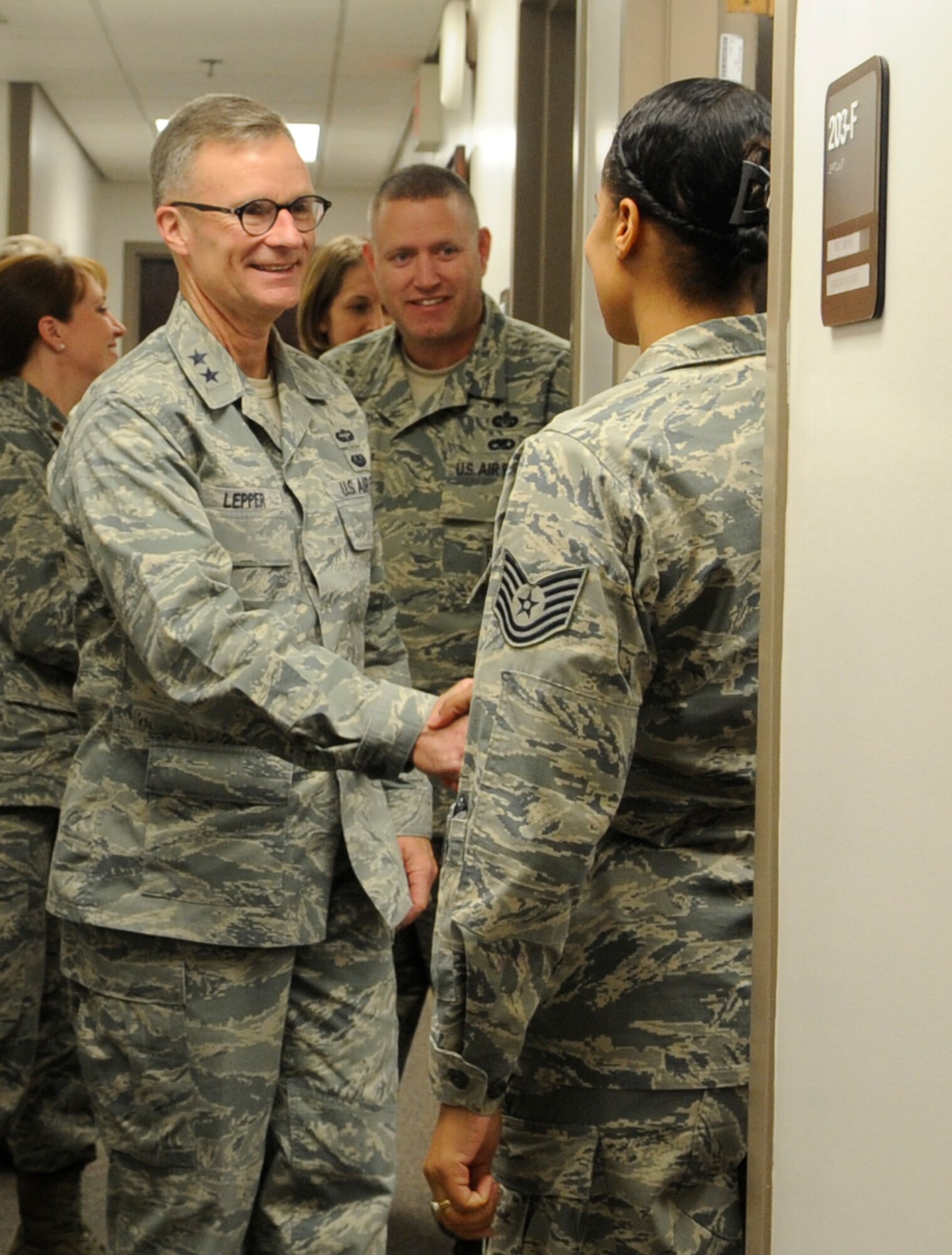 U.S. Air Force Maj. Gen Steven Lepper, Air Force deputy judge advocate general, shakes hands with U.S. Air Force Tech. Sgt. Yolanda Brown, 509th Bomb Wing NCO in charge of military justice, in the legal office at Whiteman Air Force Base, Mo., Nov. 7, 2013. Lepper visited the base to tour both the legal and Area Defense Counsel offices. (U.S. Air Force photo by Staff Sgt. Alexandra Boutte/Released)