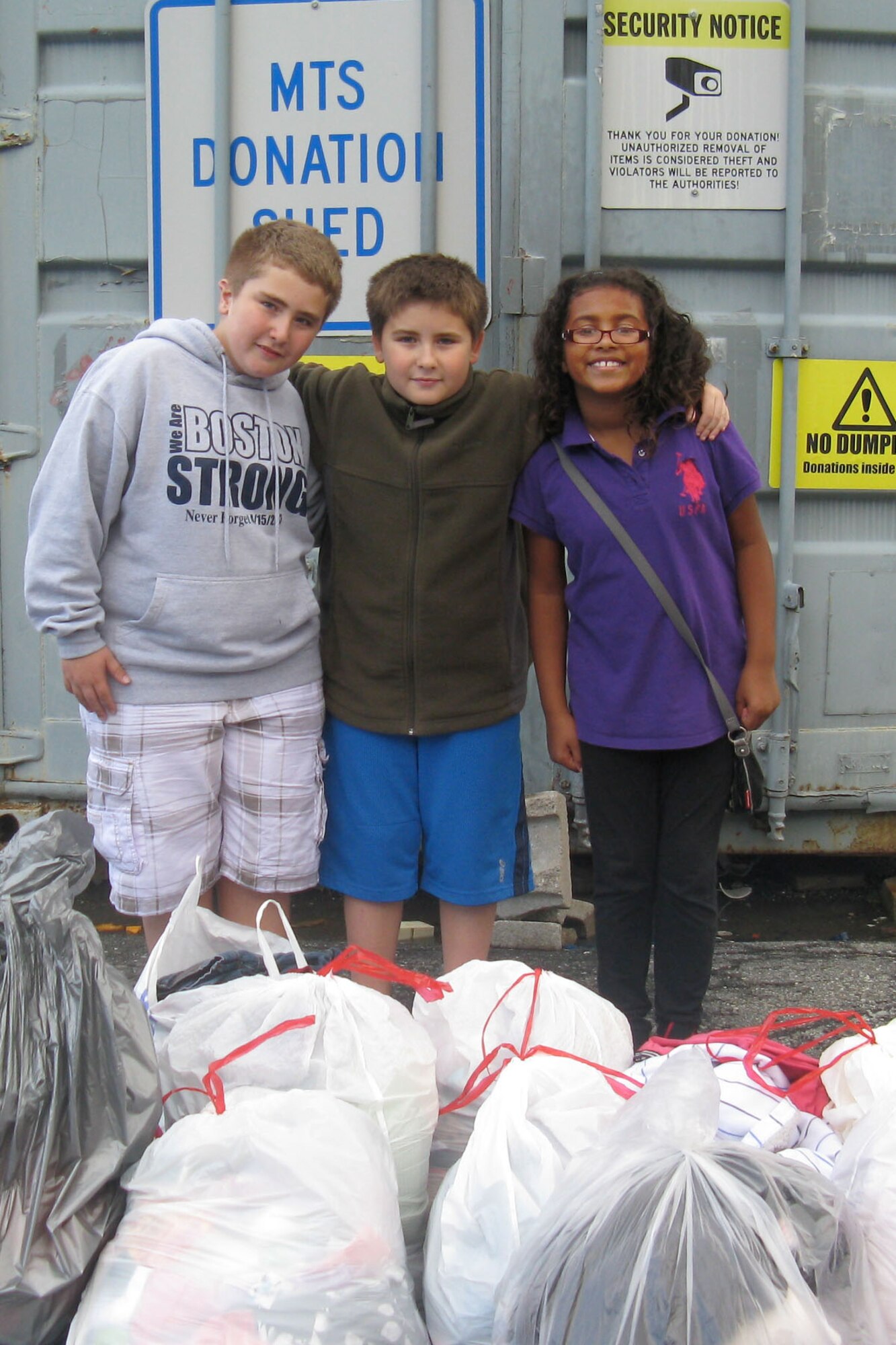 HANSCOM AIR FORCE BASE, Mass. -- Zack Fernandez (left), Kyle Fernandez (middle) and Ajhana Walls, members of the Youth Center Torch Club, a pre-teen leadership club, organized the collection and delivery of gently used clothes to the Hanscom Spouses Club Thrift Shop recently. Youth donated the clothes as admission to a recent pre-teen event at the Youth Center. (Courtesy photo)