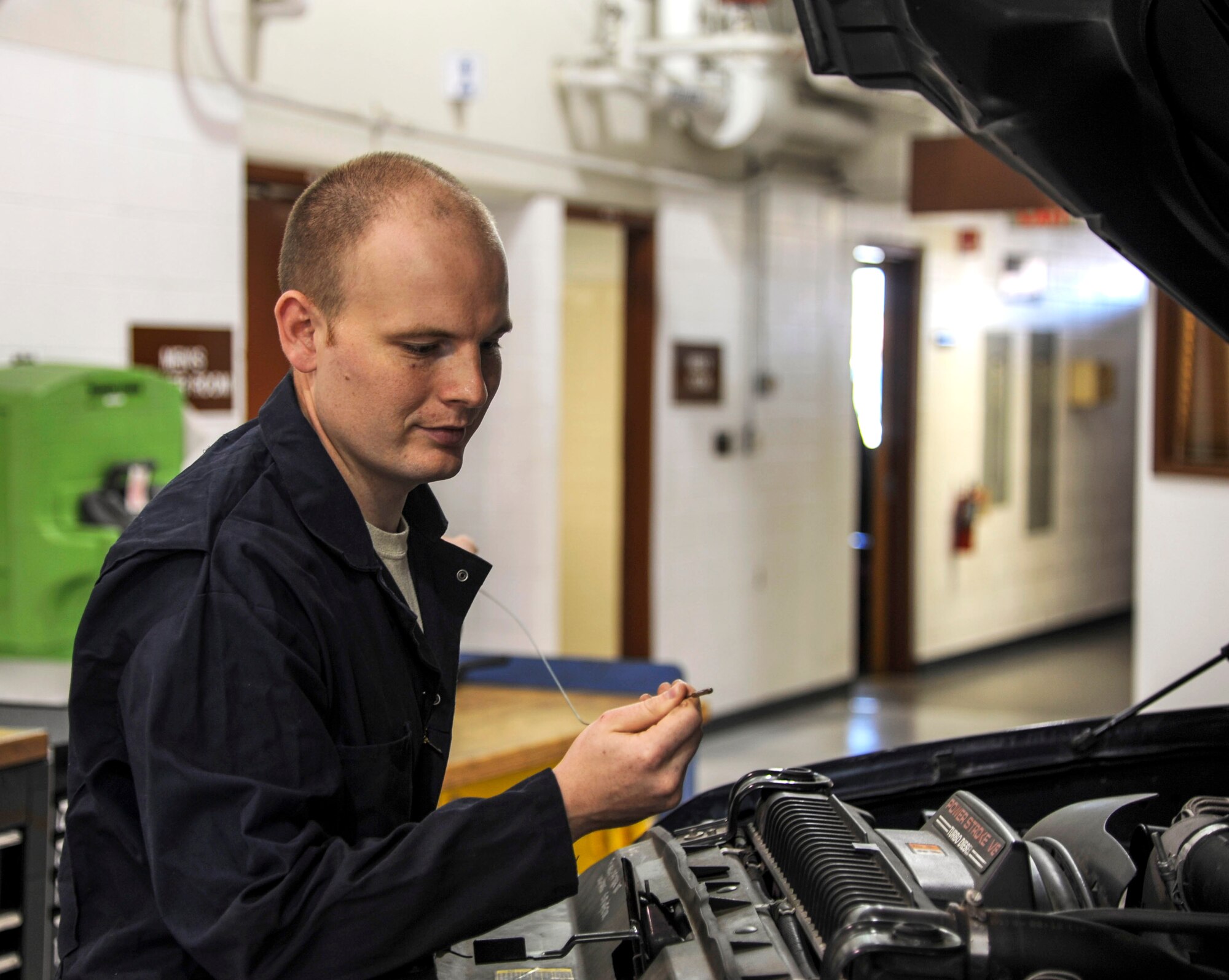 U.S. Air Force Staff Sgt. Richard W. Moore, a vehicle maintenance technician assigned to the 633rd Logistics Readiness Squadron on Joint Base Langley-Eustis, Va. checks the fluid levels of a vehicle before winter arrives November 14, 2013. (U.S. Air Force photo by Staff Sgt. Steve Stanley/Released)
