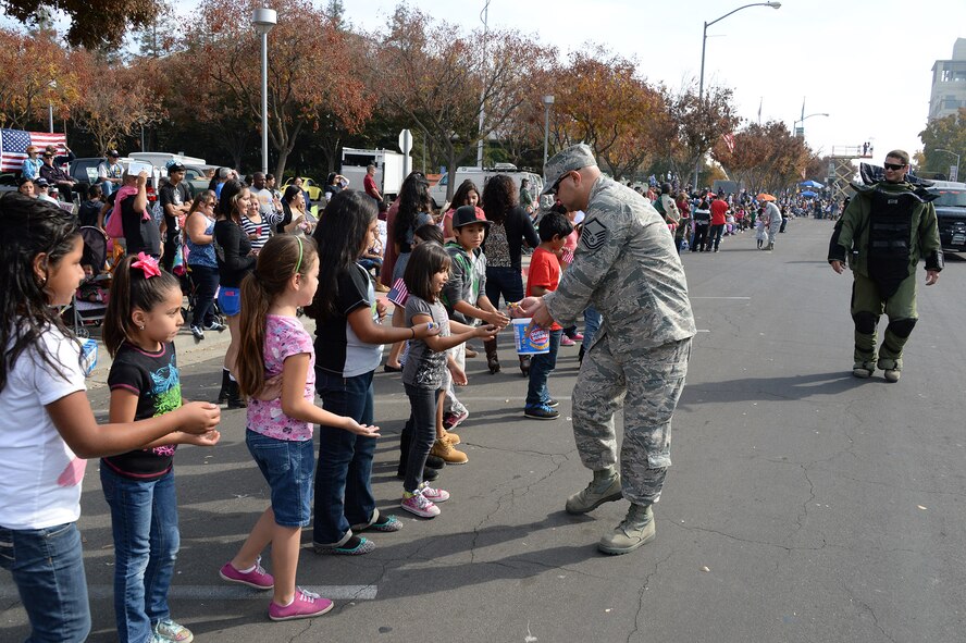 U.S. Air Force Master Sgt. Nathan Krebs, 144th Medical Group, passes out treats to children watching Fresno, California’s annual Veteran’s Day Parade Nov. 11, 2013. The parade is the largest of its type west of the Mississippi. (Air National Guard photo by Senior master Sgt. Chris Drudge)