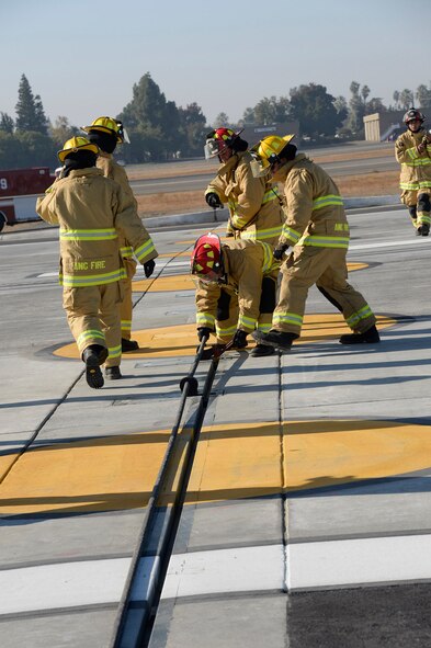 U.S. Air Force Firefighters from the 144th Fighter Wing replace the barrier cable following a successful test of the end of runway aircraft arresting system. The certification engagement exercise was held at the Fresno Yosemite International Airport on Nov. 2, 2013. (Air National Guard photograph by Tech. Sgt. Charles  Vaughn)