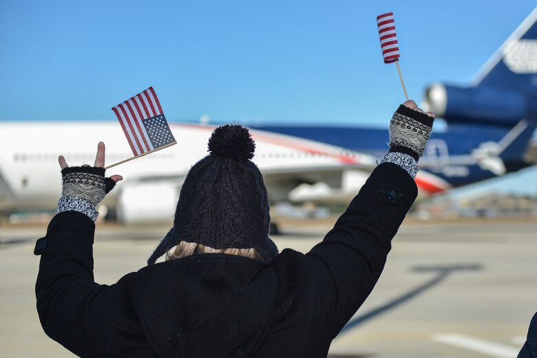 Family members of Airmen from the 117th Air Control Squadron, Georgia Air National Guard wave American flags as the Guardsmen board a plane, Nov. 13, 2013 at the Savannah Combat Readiness Training Center in Garden City, Ga. About 110 members of 117ACS have deployed for six months to Southwest Asia in support of Operation Enduring Freedom. (U.S. Air National Guard photo by Master Sgt. Charles Delano/released)