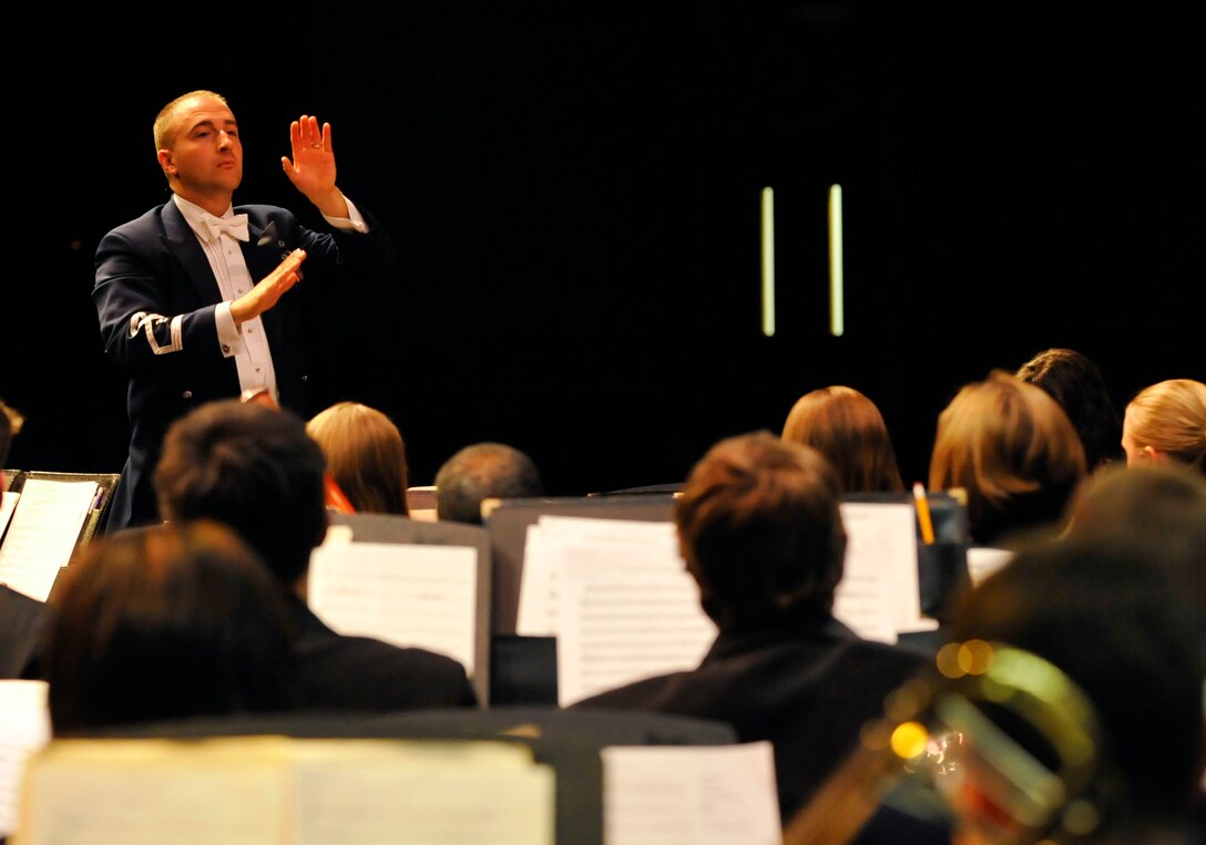 U.S. Air Force 2nd Lt. Justin Lewis, U.S. Air Force Heritage of America Band conductor, leads a band made up of more than 90 musicians from the USAF Heritage of American Band and the College of William and Mary Wind Ensemble in an armed services medley during their “Side by Side” concert at Warhill High School in Williamsburg, Va., Nov. 14, 2013. The bands played more than 11 songs during the two-hour concert that drew a crowd of more than 400 people. (U.S. Air Force photo by Staff Sgt. Wesley Farnsworth/Released)