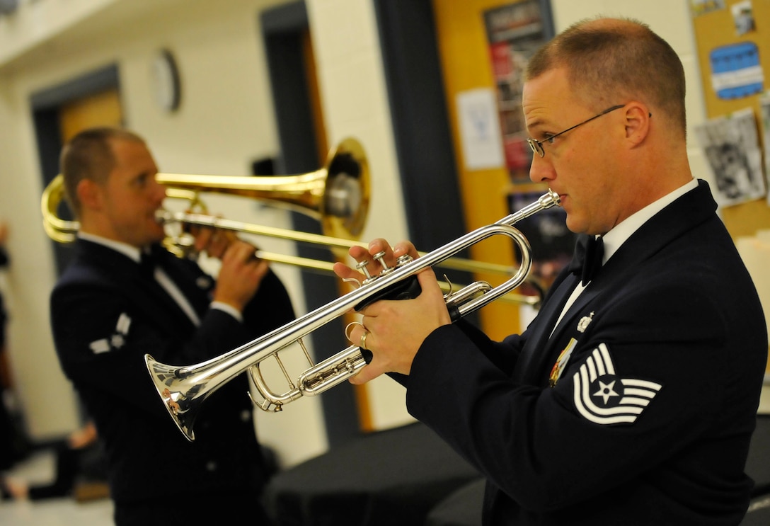 From right, U.S. Air Force Heritage of America Band members Tech. Sgt. Mark Nixon, trumpeter, and Airman 1st Class Trent Lockhart, tromboneist, warm up prior to the start of their “Side by Side” concert with the College of William and Mary Wind Ensemble at Warhill High School in Williamsburg, Va., Nov. 14, 2013. The bands played more than 11 songs during the two-hour concert that drew a crowd of more than 400 people. (U.S. Air Force photo by Staff Sgt. Wesley Farnsworth/Released)
