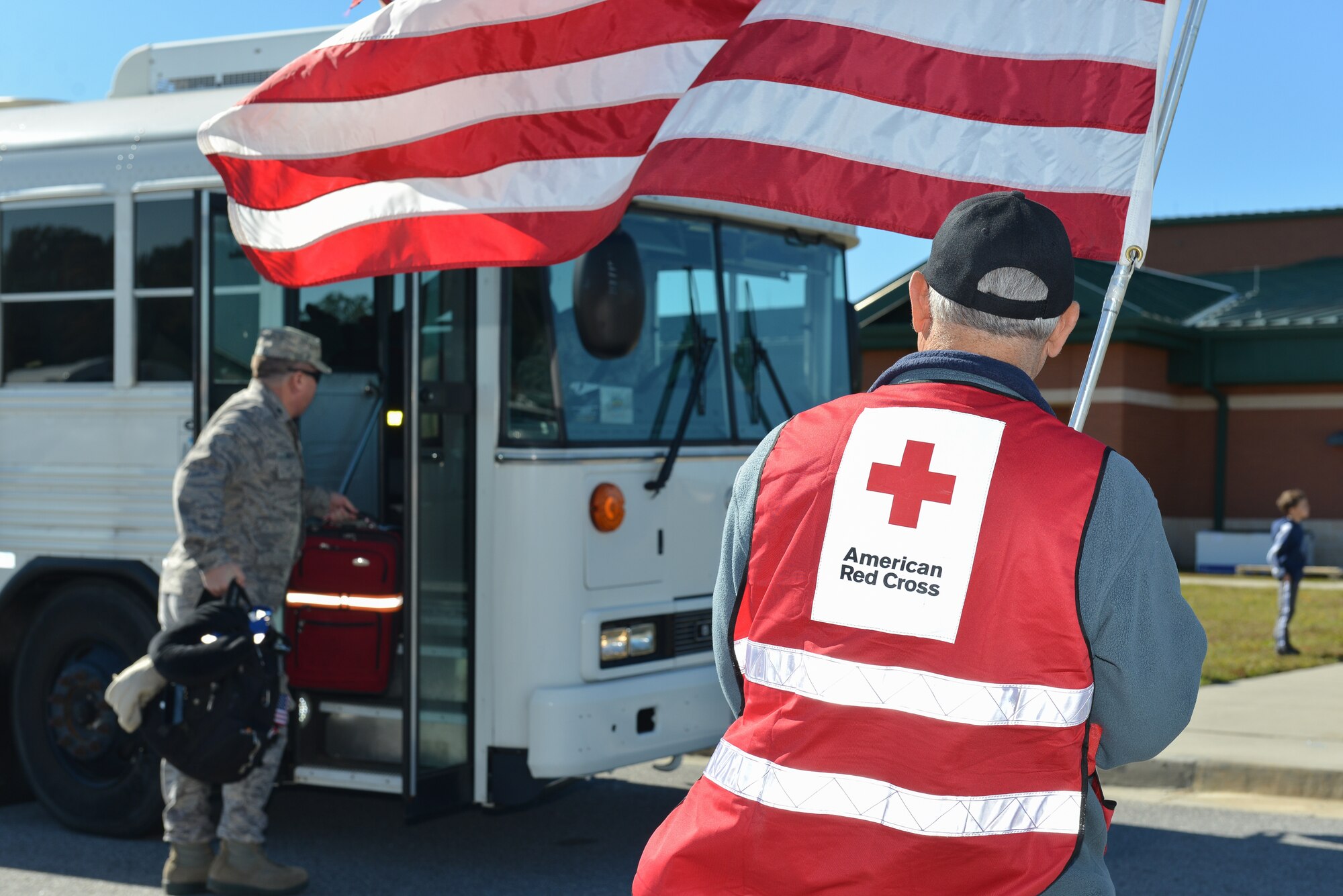 Members from the USO and Red Cross provide flags and deployment bags full of hygiene items and snacks to deploying Georgia Air National Guard Airmen, Nov. 12, 2013 at Savannah Air National Guard base in Garden City, Ga. About 110 members of 117ACS have deployed for six months to Southwest Asia in support of Operation Enduring Freedom. (U.S. Air National Guard photo by Master Sgt. Charles Delano/released)