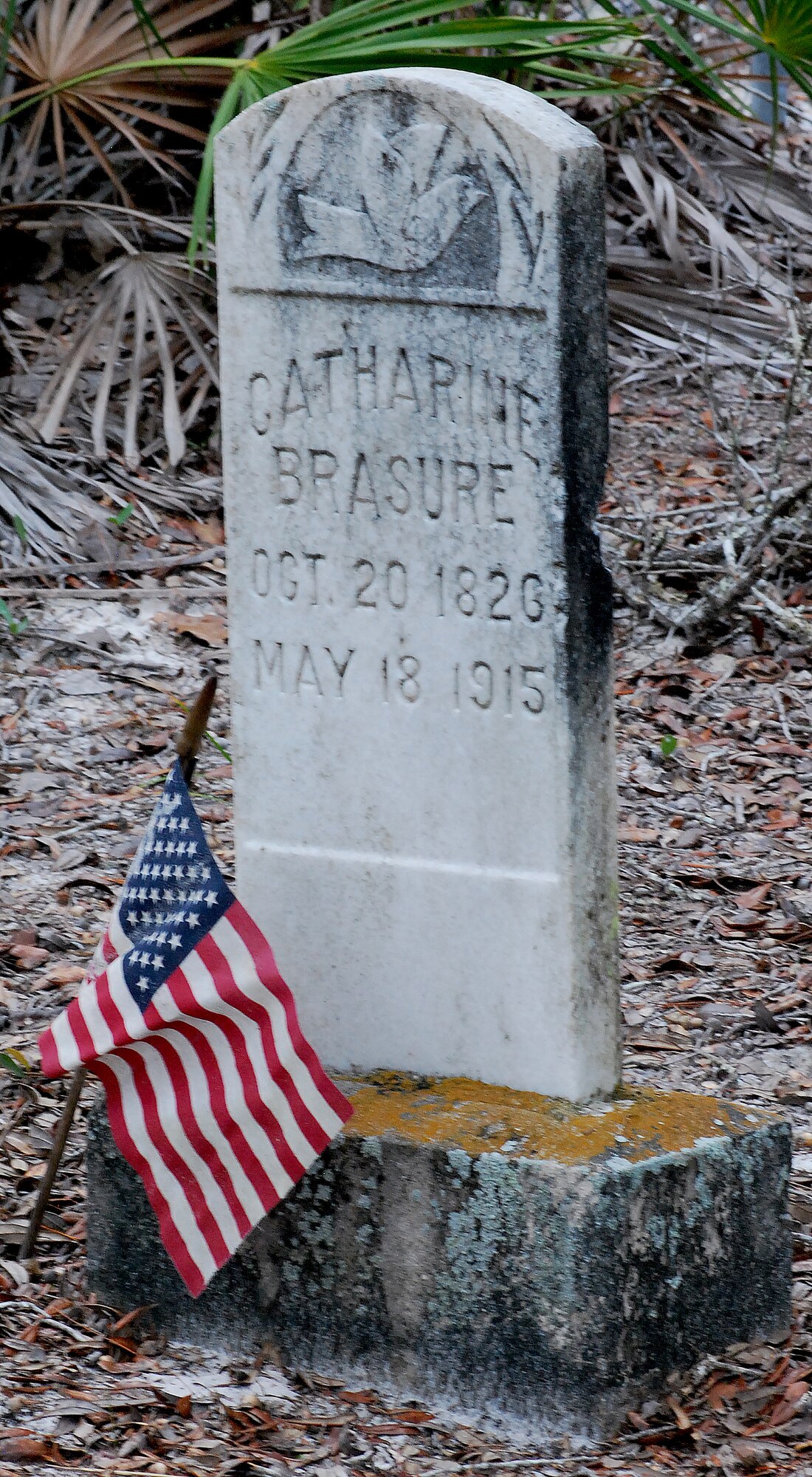 An American flag waves peacefully over a headstone at Marywood Cemetery.  Marywood Cemetery is one of eleven grave sites at Tyndall. (U.S. Air Force photo by 2nd Lieutenant Christopher Bowyer-Meeder)