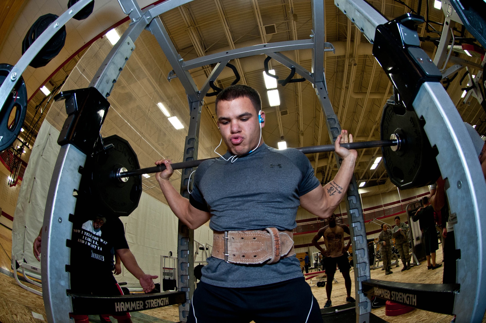 Senior Airman Brandon Stout, 28th Civil Engineer Squadron Fire Department driver operator, performs squats during a powerlifting competition in the Bellamy Fitness Center at Ellsworth Air Force Base, S.D., Nov. 13, 2013.The competition was open to all Ellsworth personnel and their families, and required participants to complete a one-repetition maximum in a bench press, squat and dead lift. (U.S. Air Force photo by Senior Airman Zachary Hada/Released)